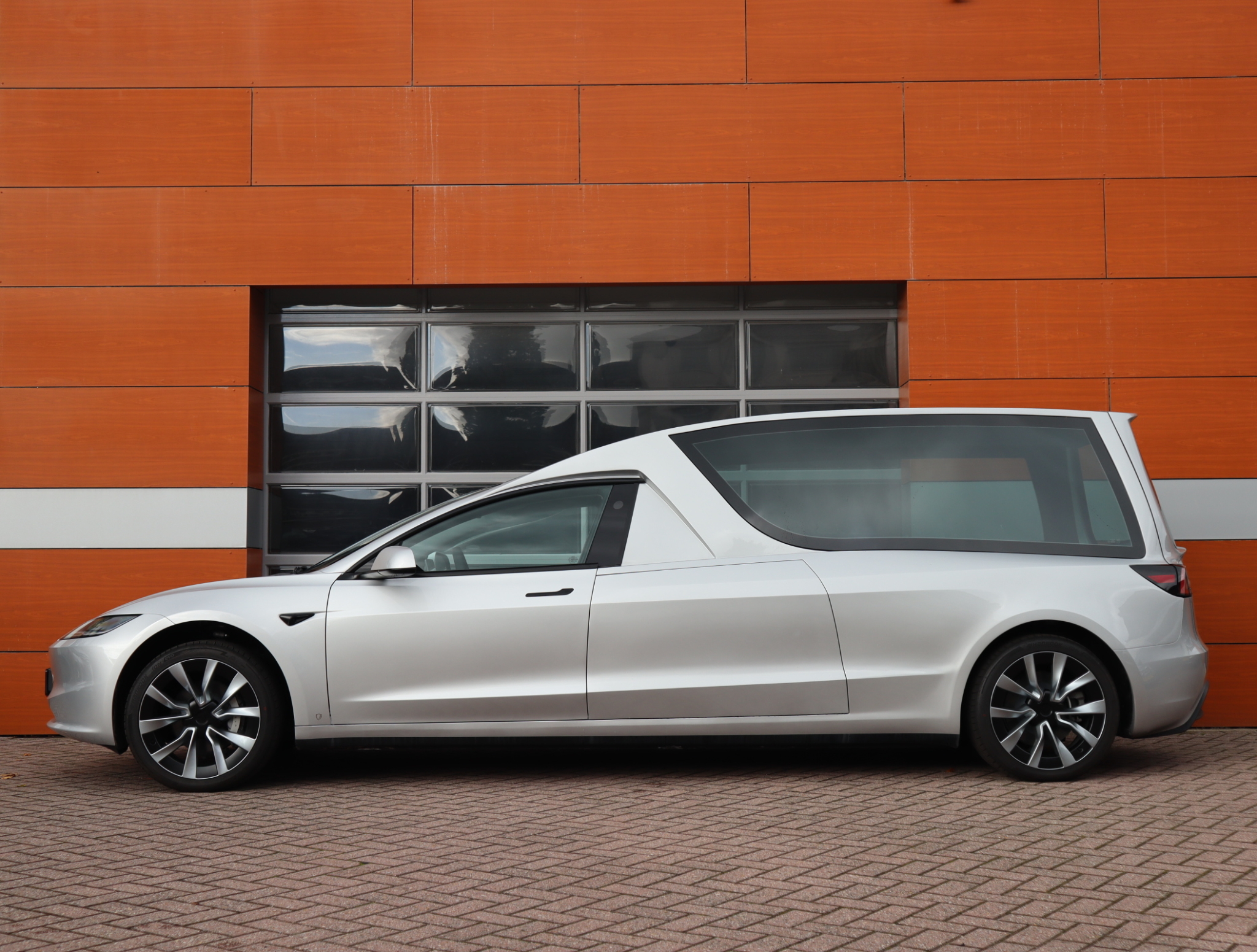 Zijaanzicht van de Tesla Model 3 E-Hearse rouwauto