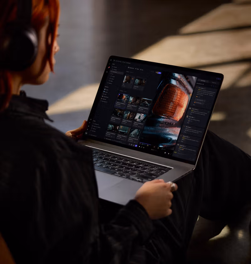 Personne avec casque écoutant un ordinateur portable affichant une interface de gestion de fichiers vidéo.