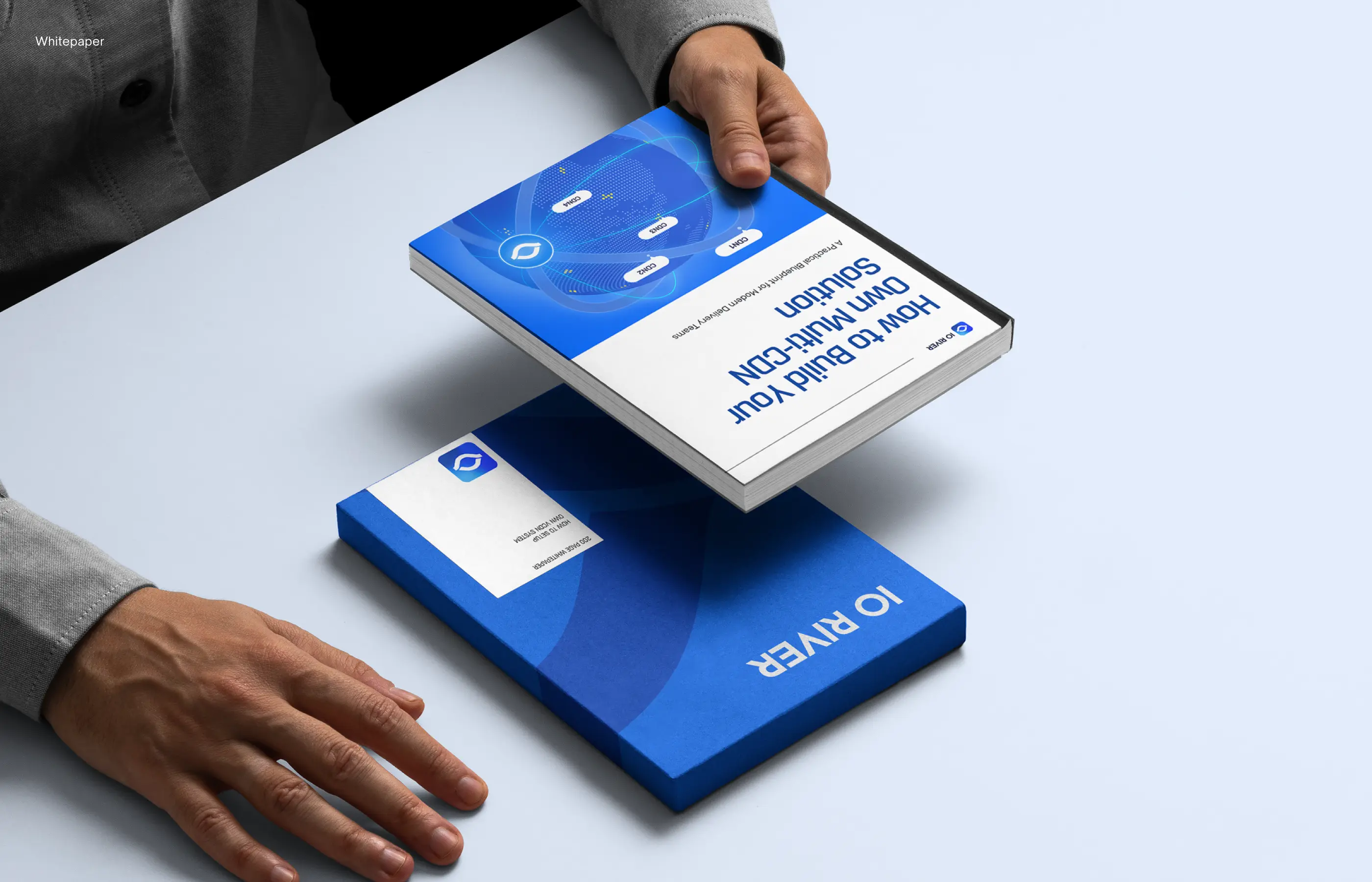Person holding a book titled 'How to Build Your Own Multi-Coin Solution' next to another blue book.