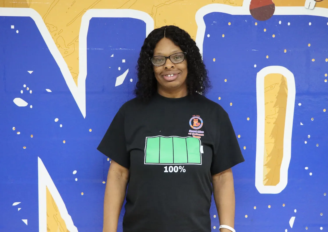 Staff member wearing black shirt with battery graphic