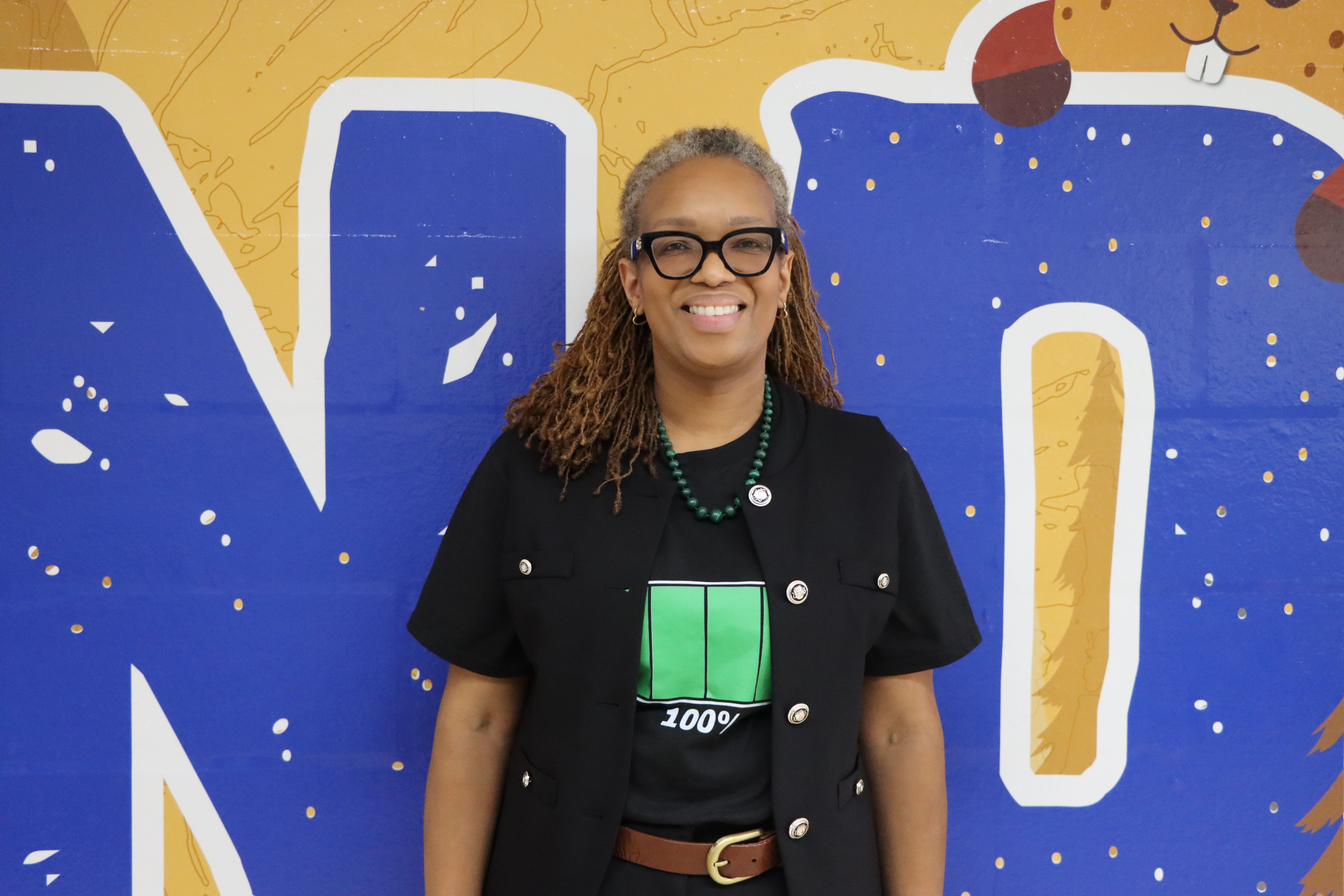 Felicha Daley staff portrait with colorful mural backdrop