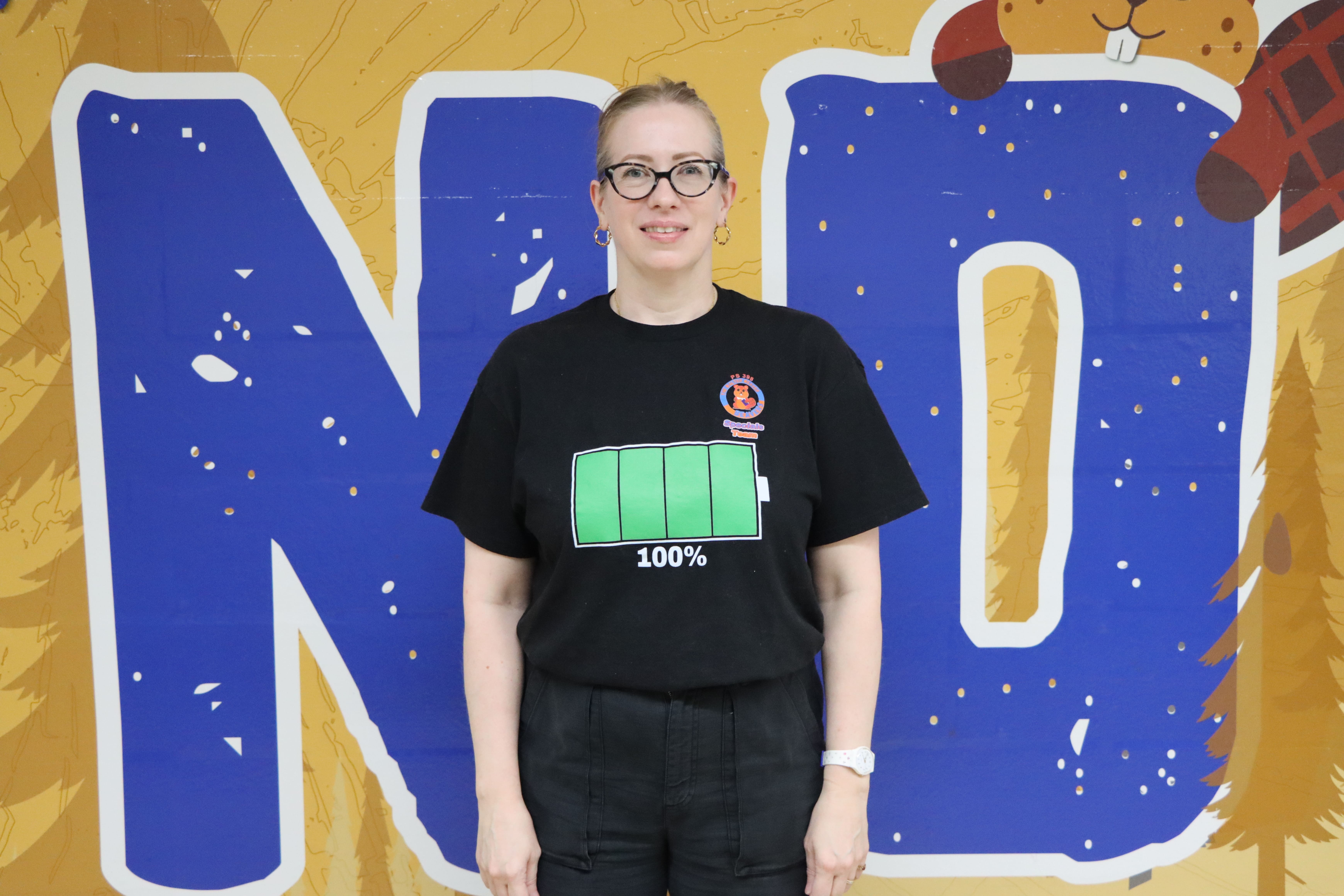Staff member wearing battery graphic shirt smiling for portrait