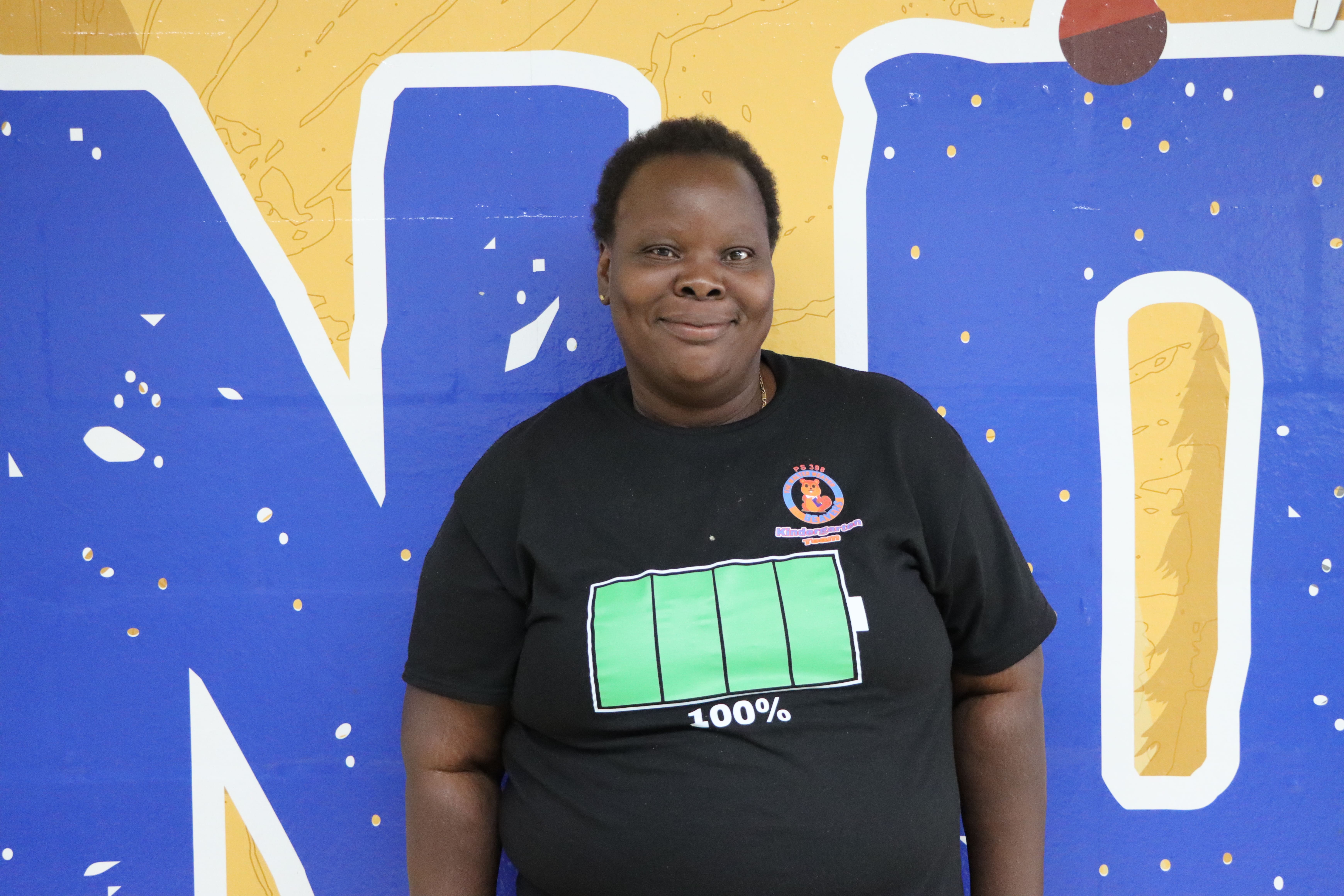 Staff member in front of colorful mural wall