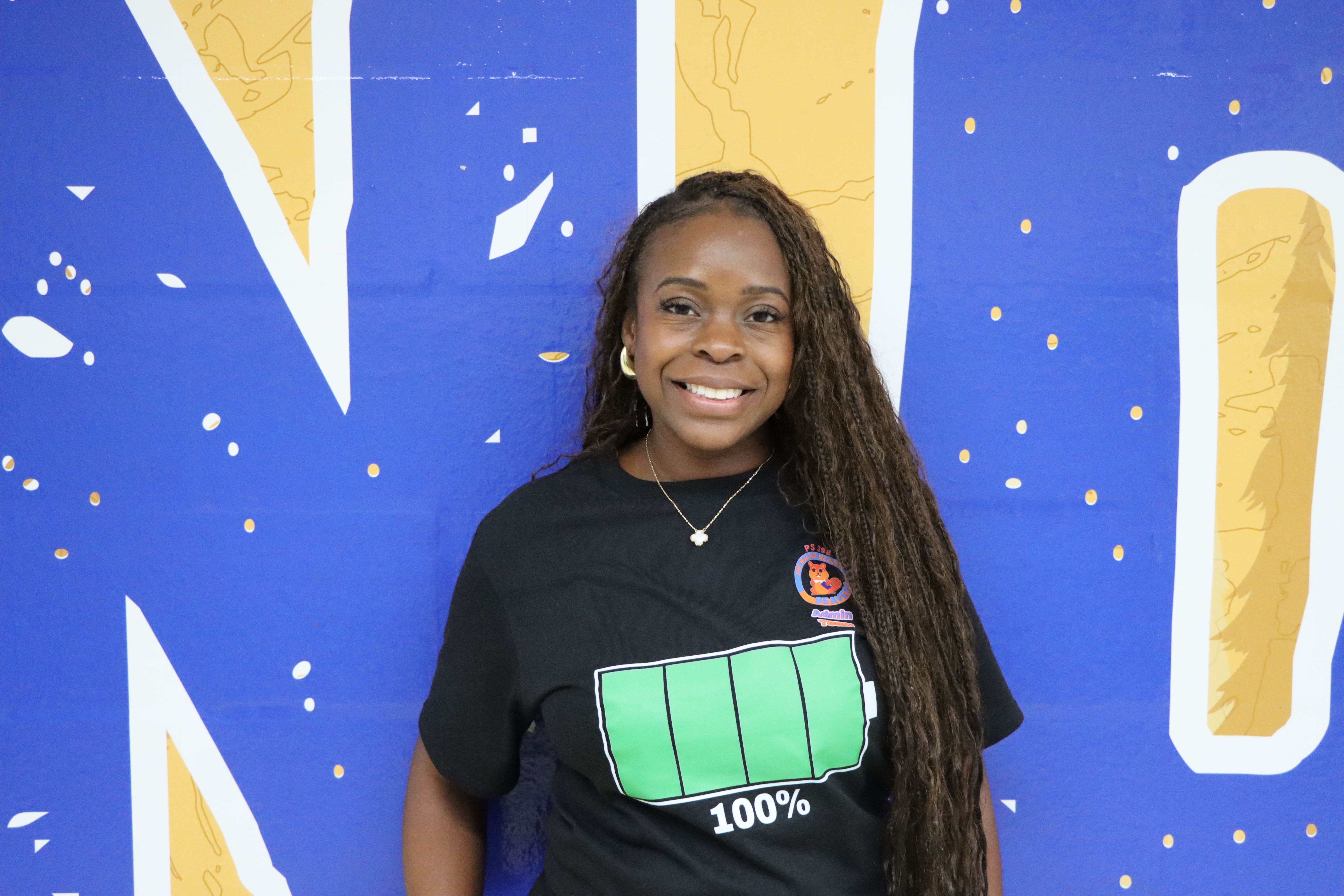 Ariana Butler Bass poses in front of blue and yellow wall