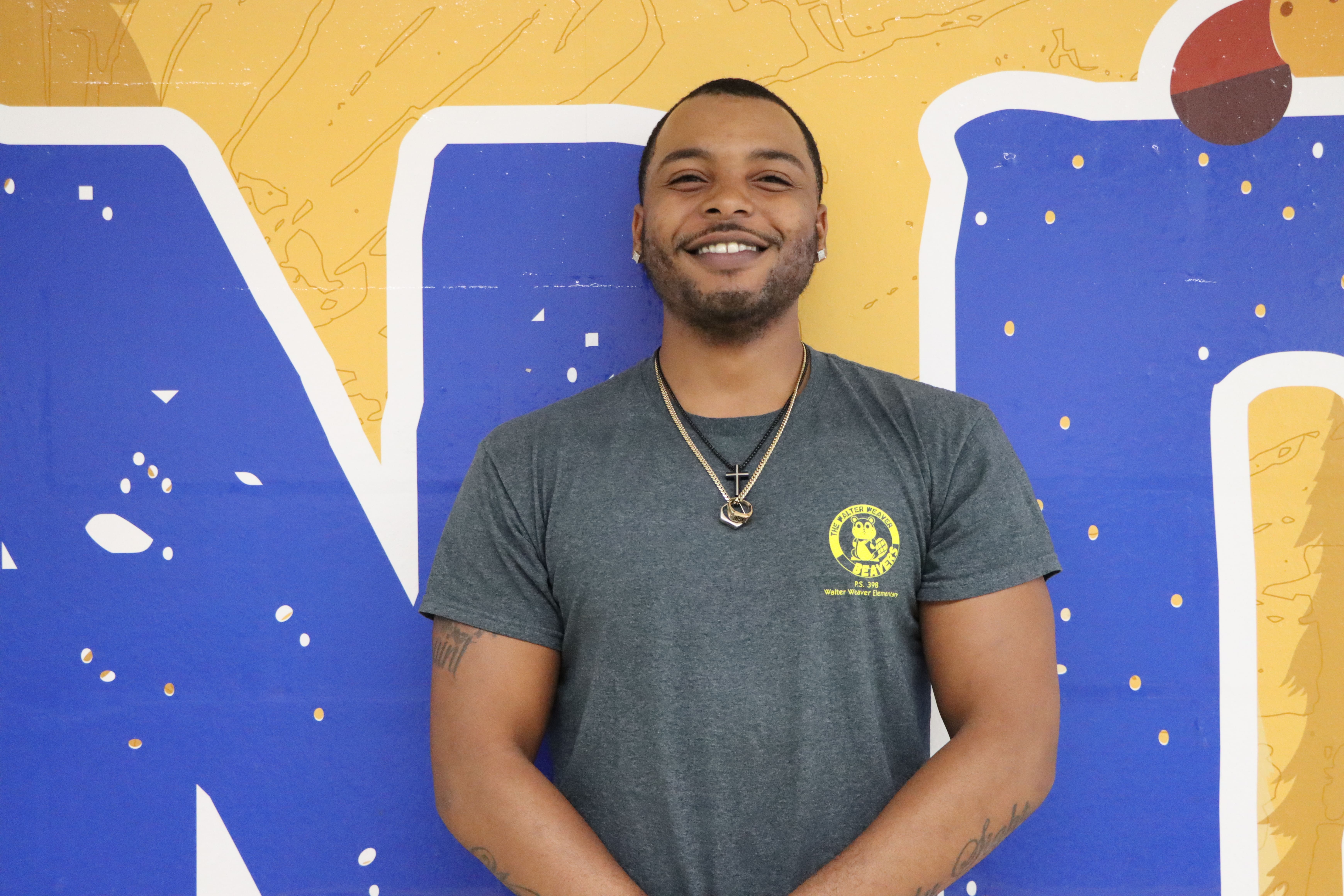Staff member portrait against blue and yellow mural