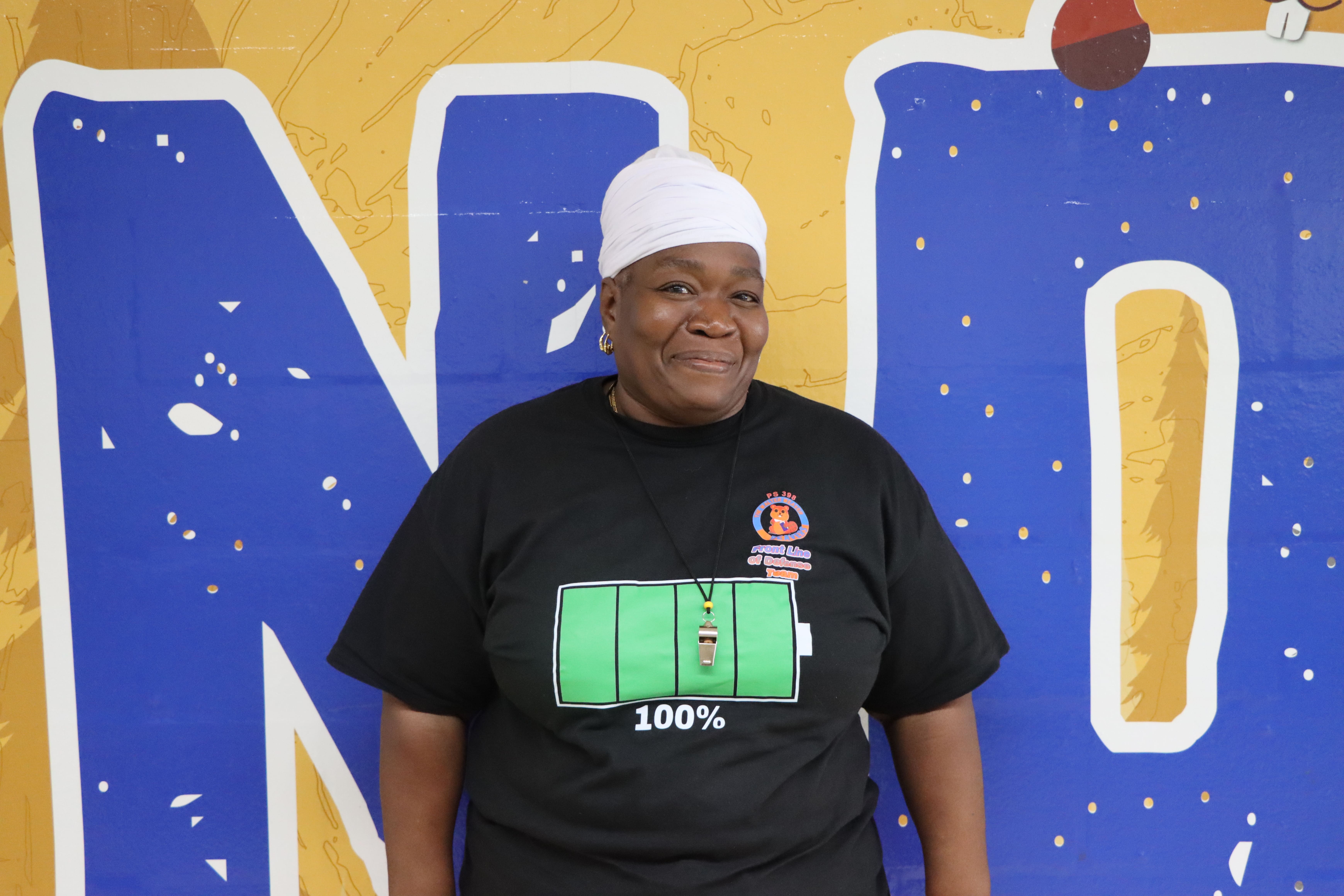 Debra Geathers wearing black staff shirt with white head wrap