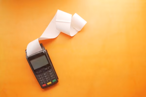 a cell phone sitting on top of a table next to a roll of paper