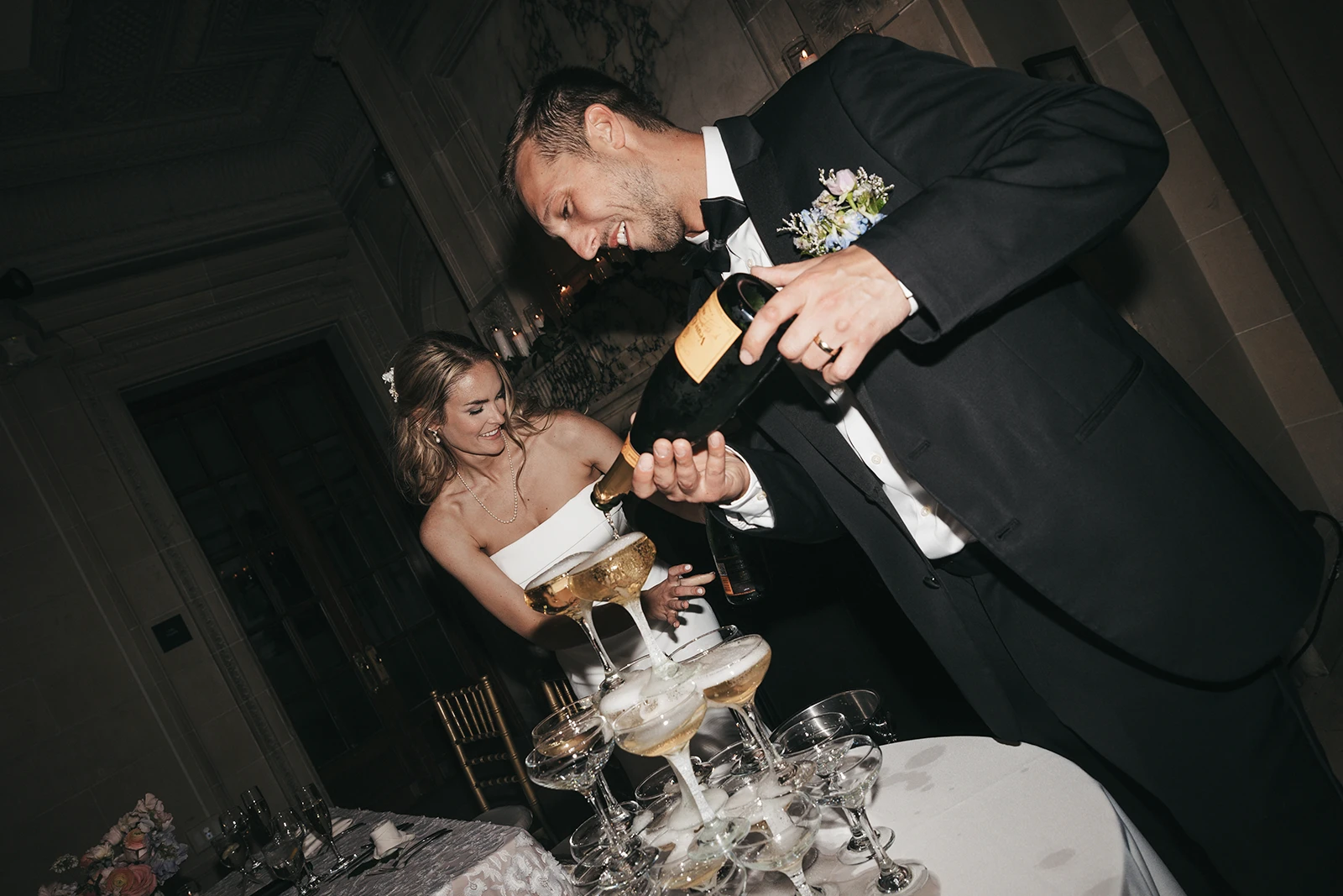 A groom pouring champagne at his wedding reception.