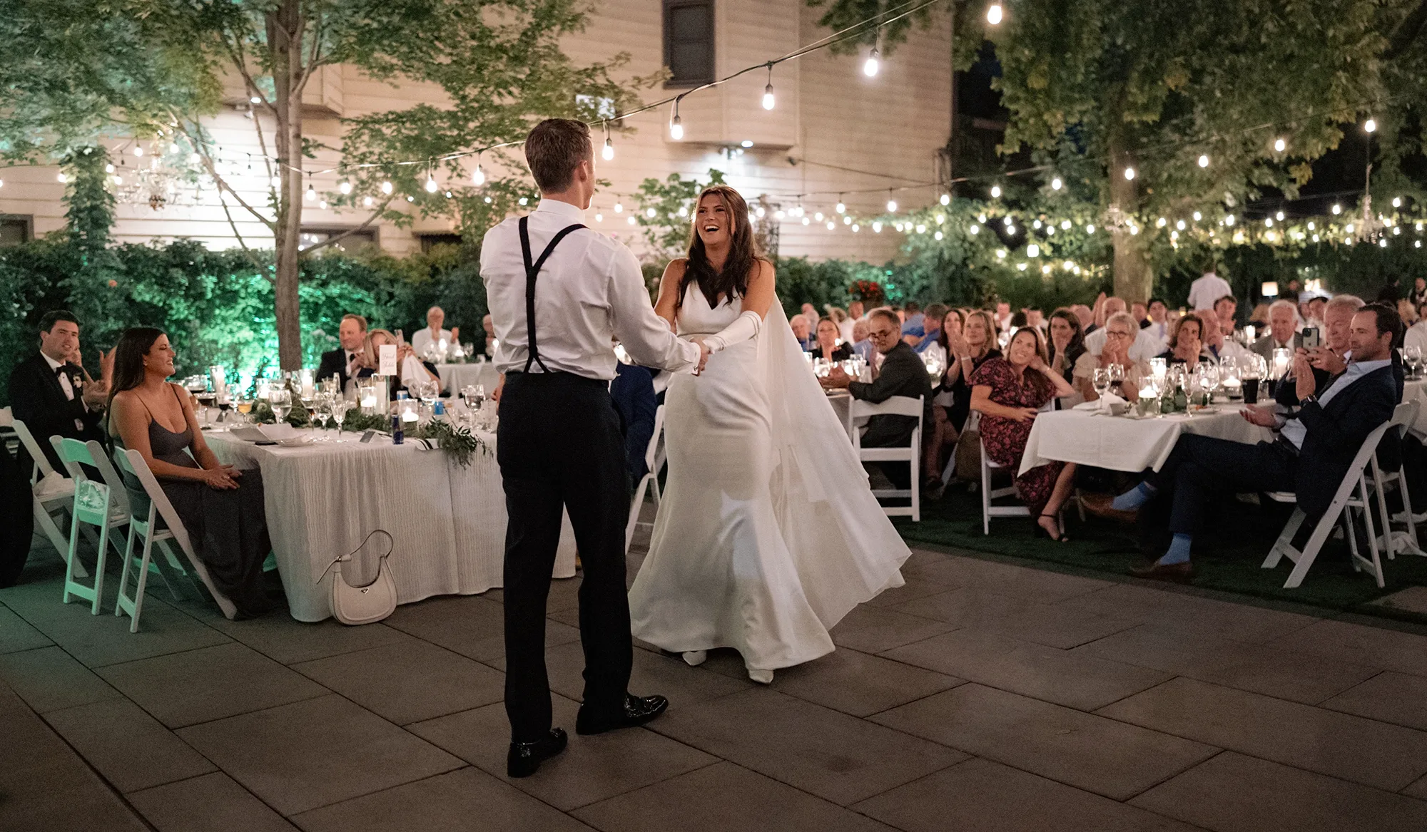 A couple dancing outside at their wedding reception.