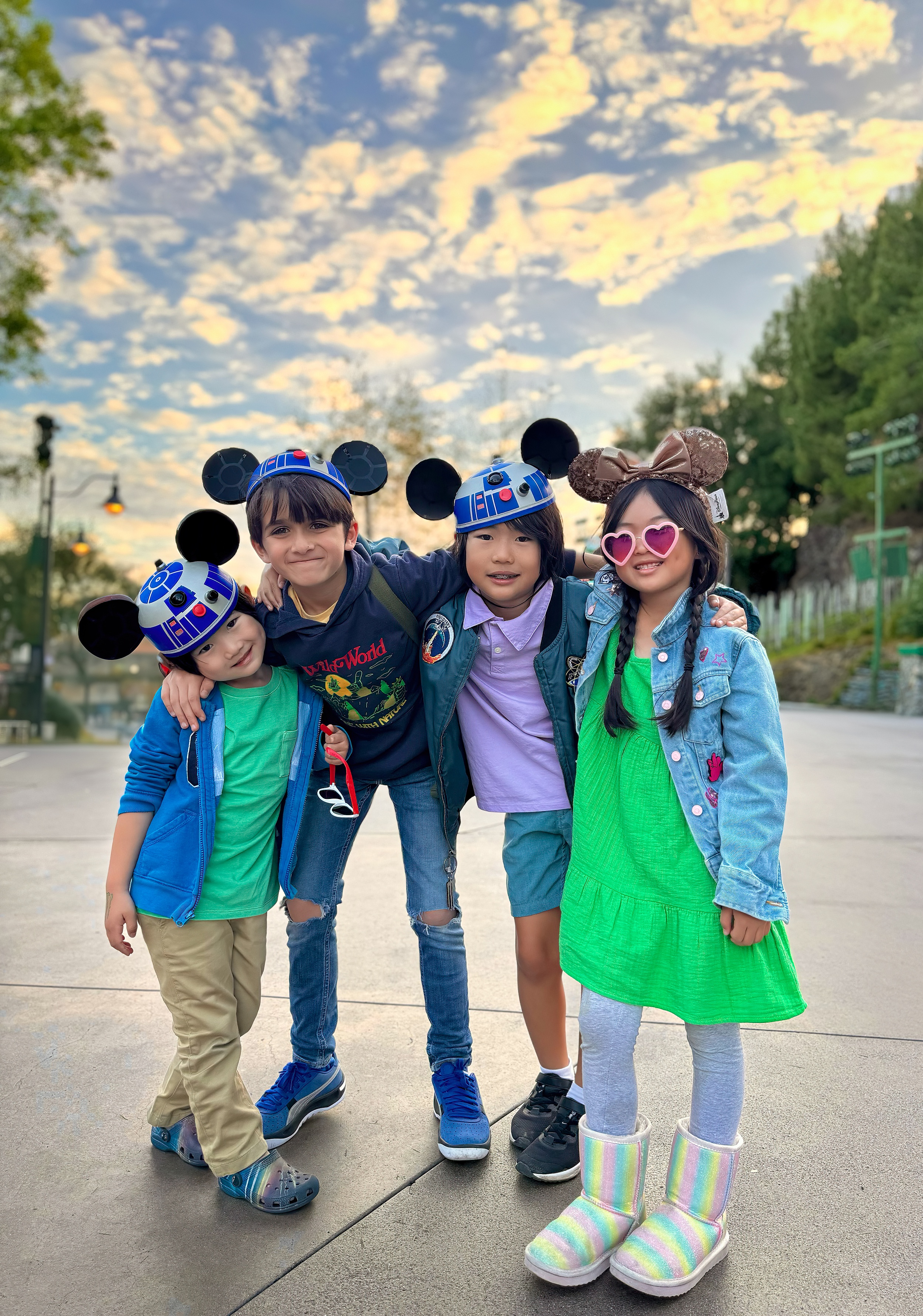 A family of 4 stand together in Mickey hats at Disney thanks to Hands-Free Photos On An iPhone