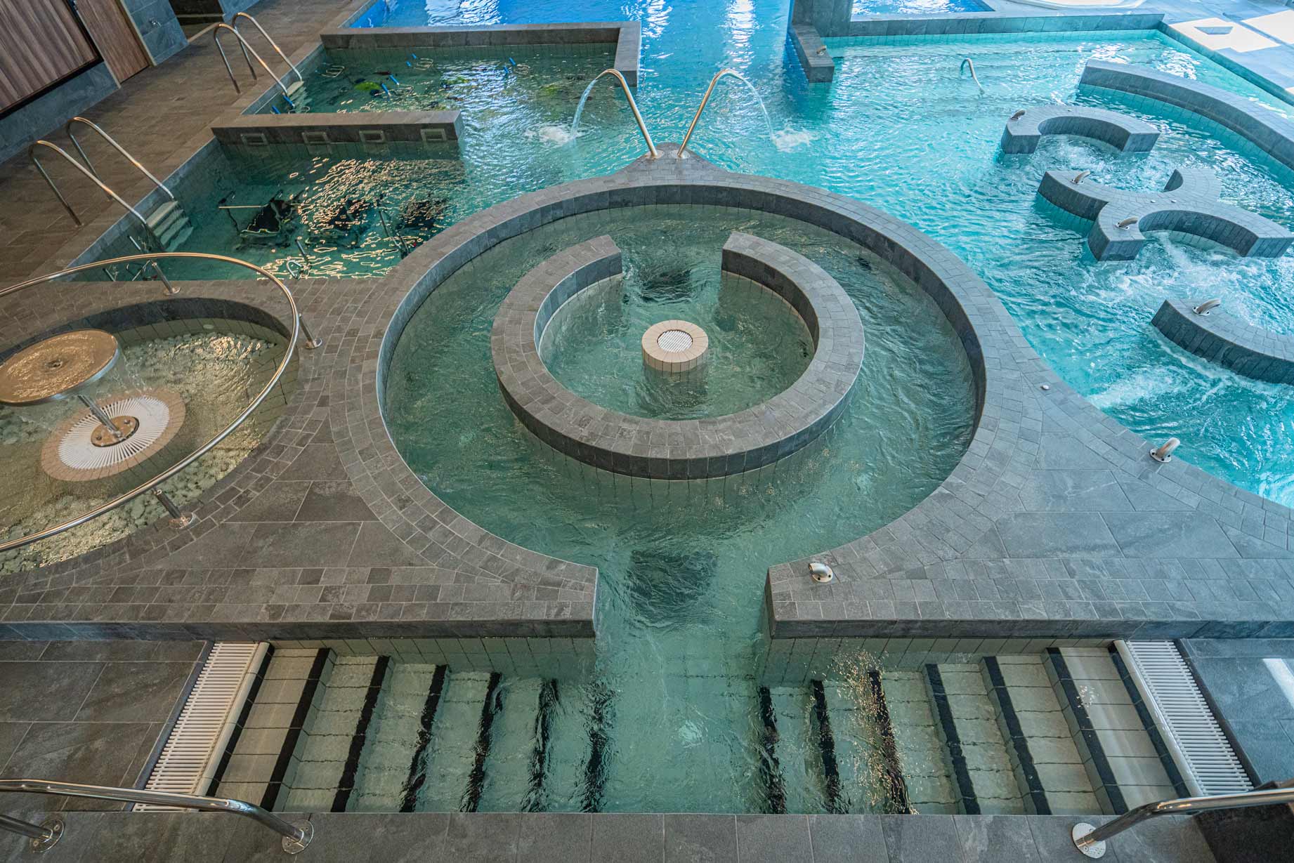 piscine en mosaïque avec différents espaces de détente