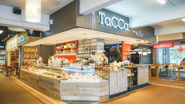 stand lumineux qui vend des plats de traiteur au milieu des halles paul bocuses