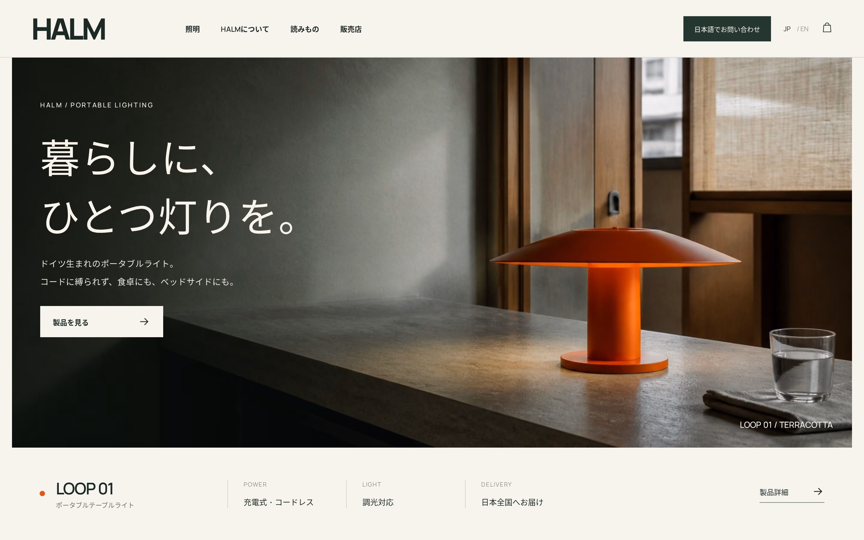 Modern orange portable table lamp on a concrete countertop in a softly lit room with wooden window frames and a glass of water nearby, displayed on a minimalist webpage for HALM lighting products in Japanese.