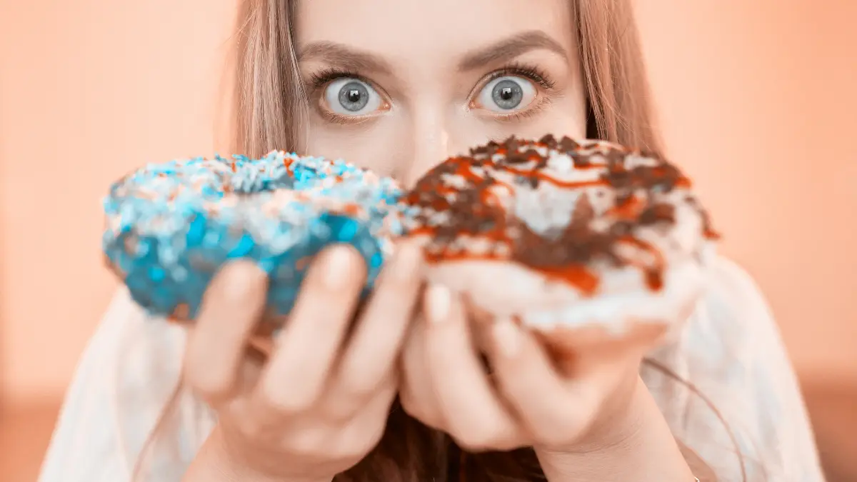 Žena drzi dvije donut krofne koje testiraju njenu volju