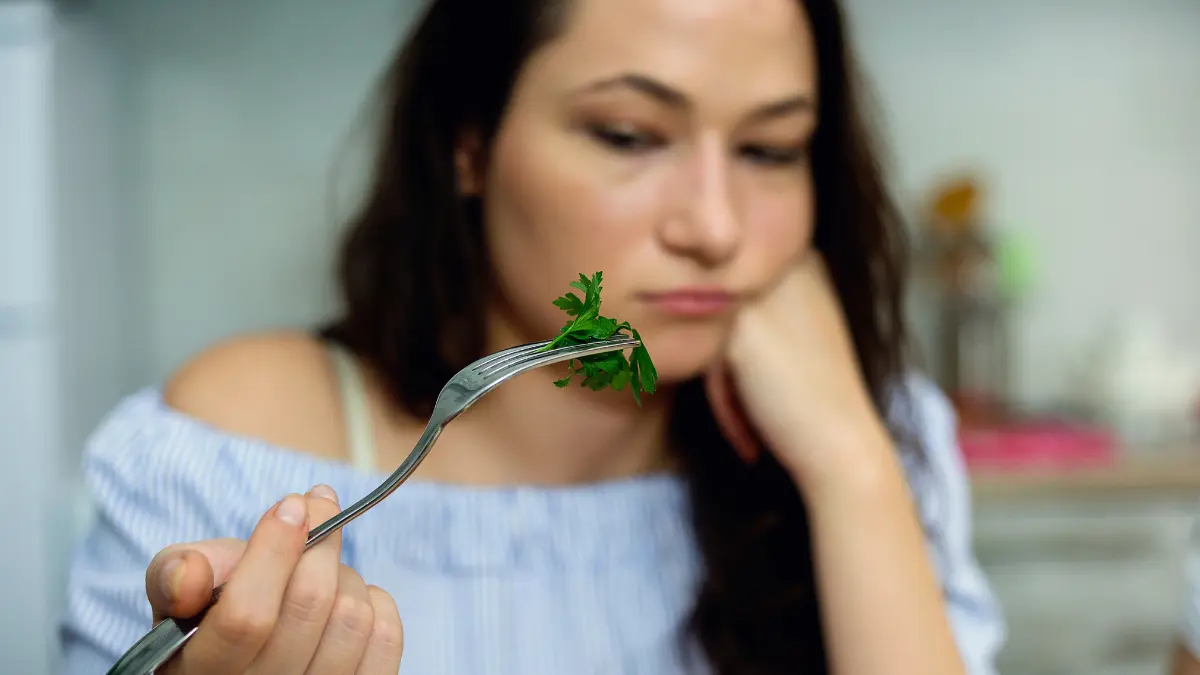 žena razočarano gleda u peršin na viljušci jer dijeta za mršavljenje ne pali i nije održiva