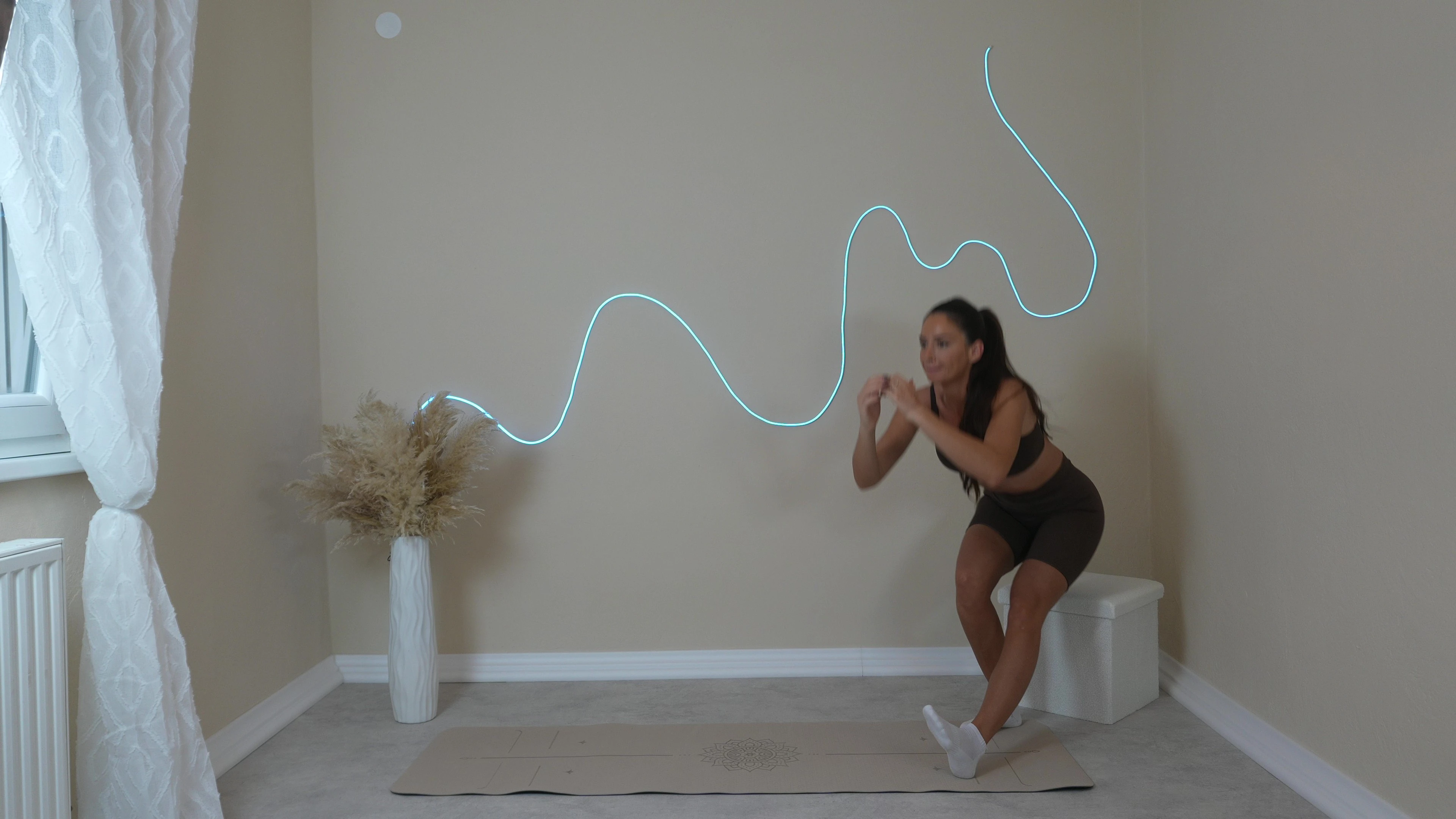 Antonia kod kuće radi trening za noge - vjezba Chair-supported pistol squat