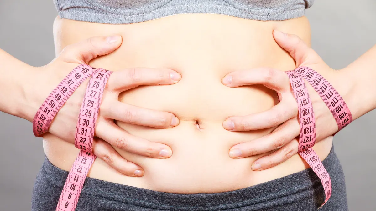 žena se drži za stomak s metrom u rukama pokazujući na neefikasnost flastera za mršavljenje