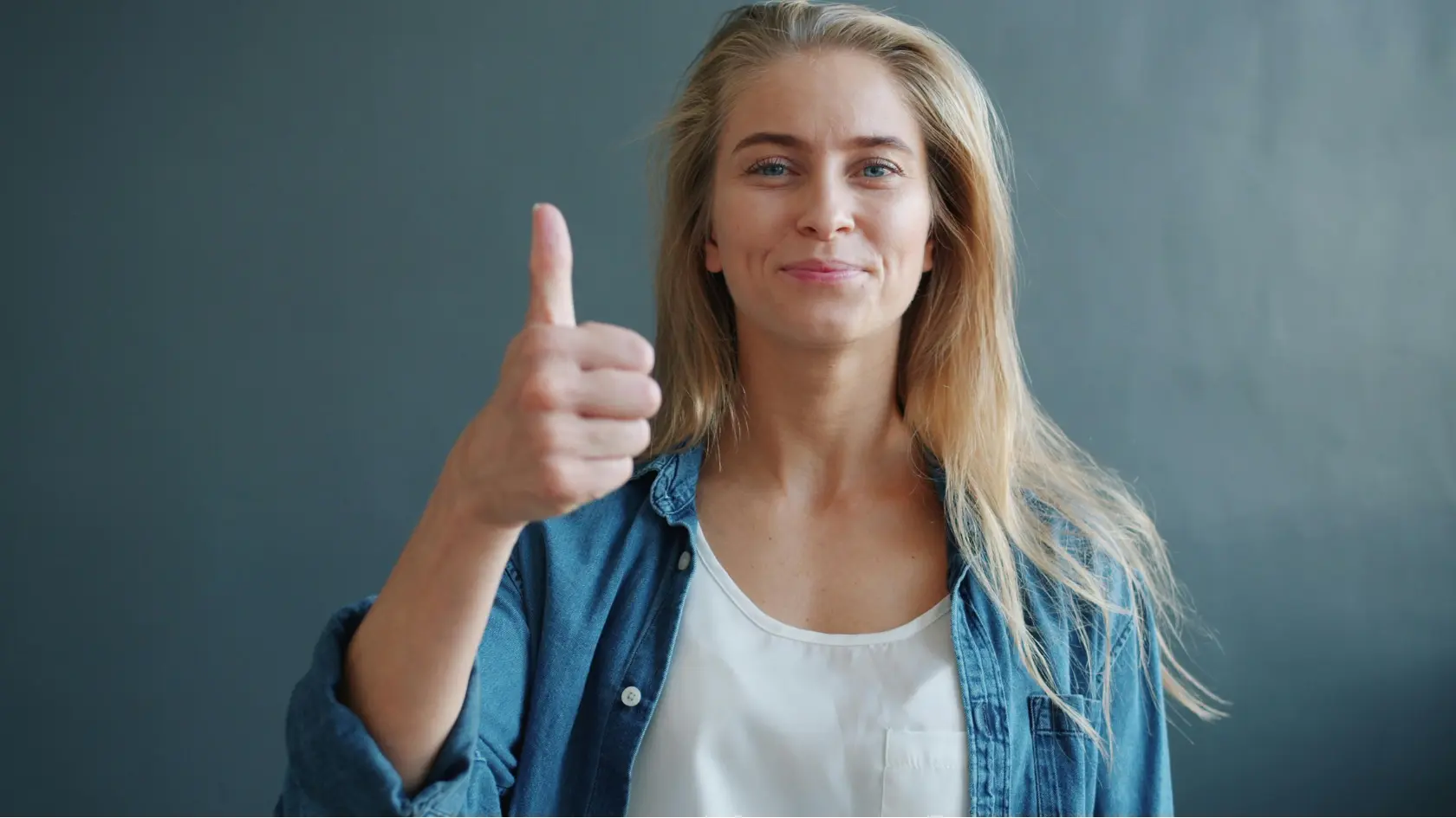 A blond, healthy woman showing thumbs up for weight loss motivation