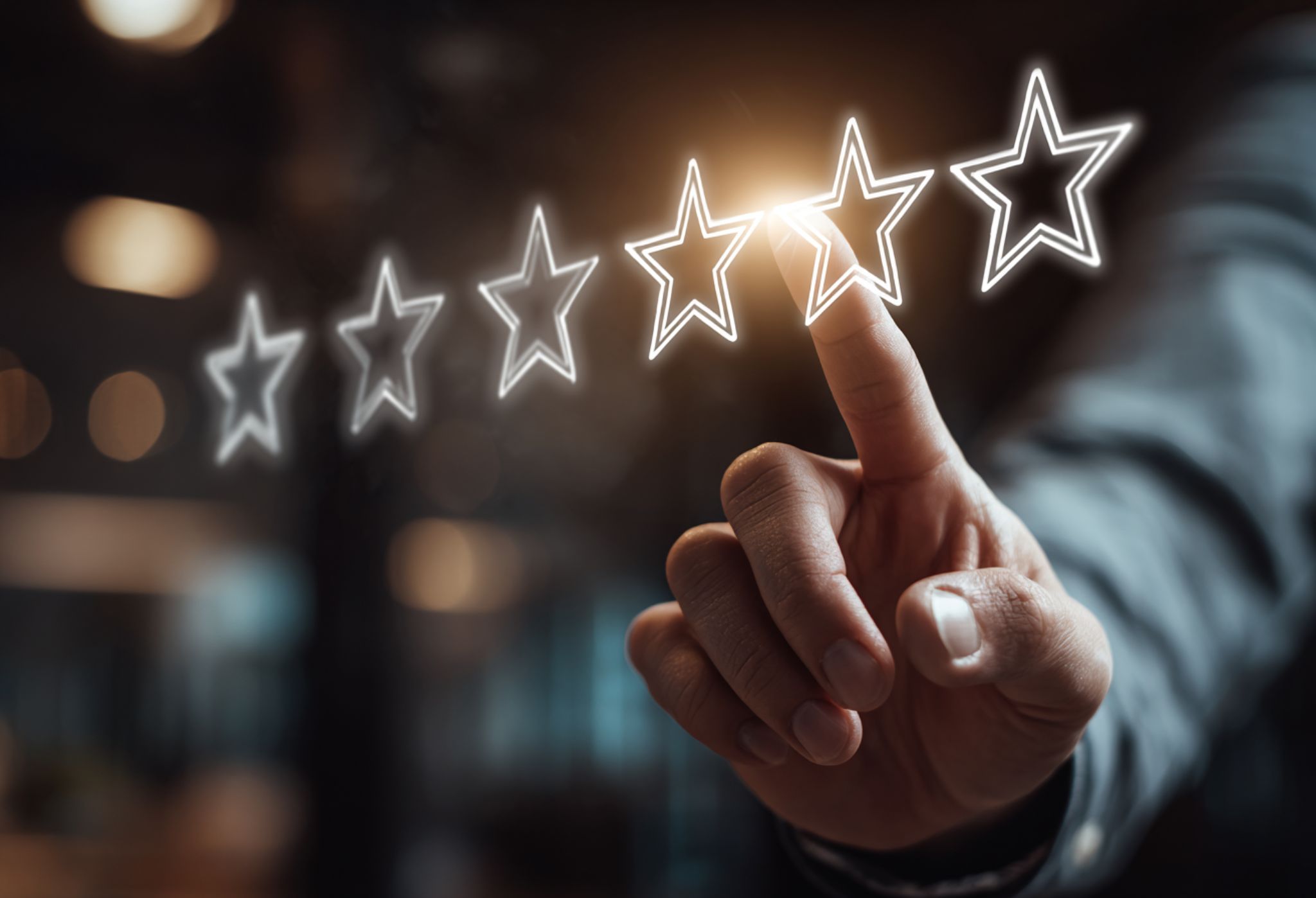 A hand in a suit jacket points at glowing, outlined stars in a dimly-lit setting. One star shines brightly, suggesting focus on quality or rating.