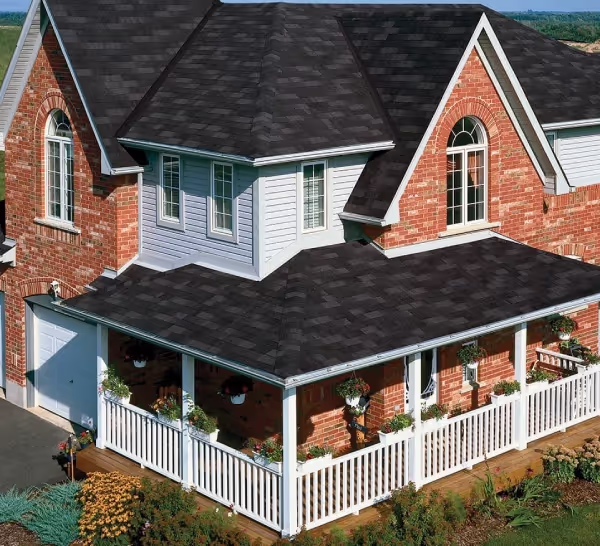 A red brick house with white trim and a black roof.