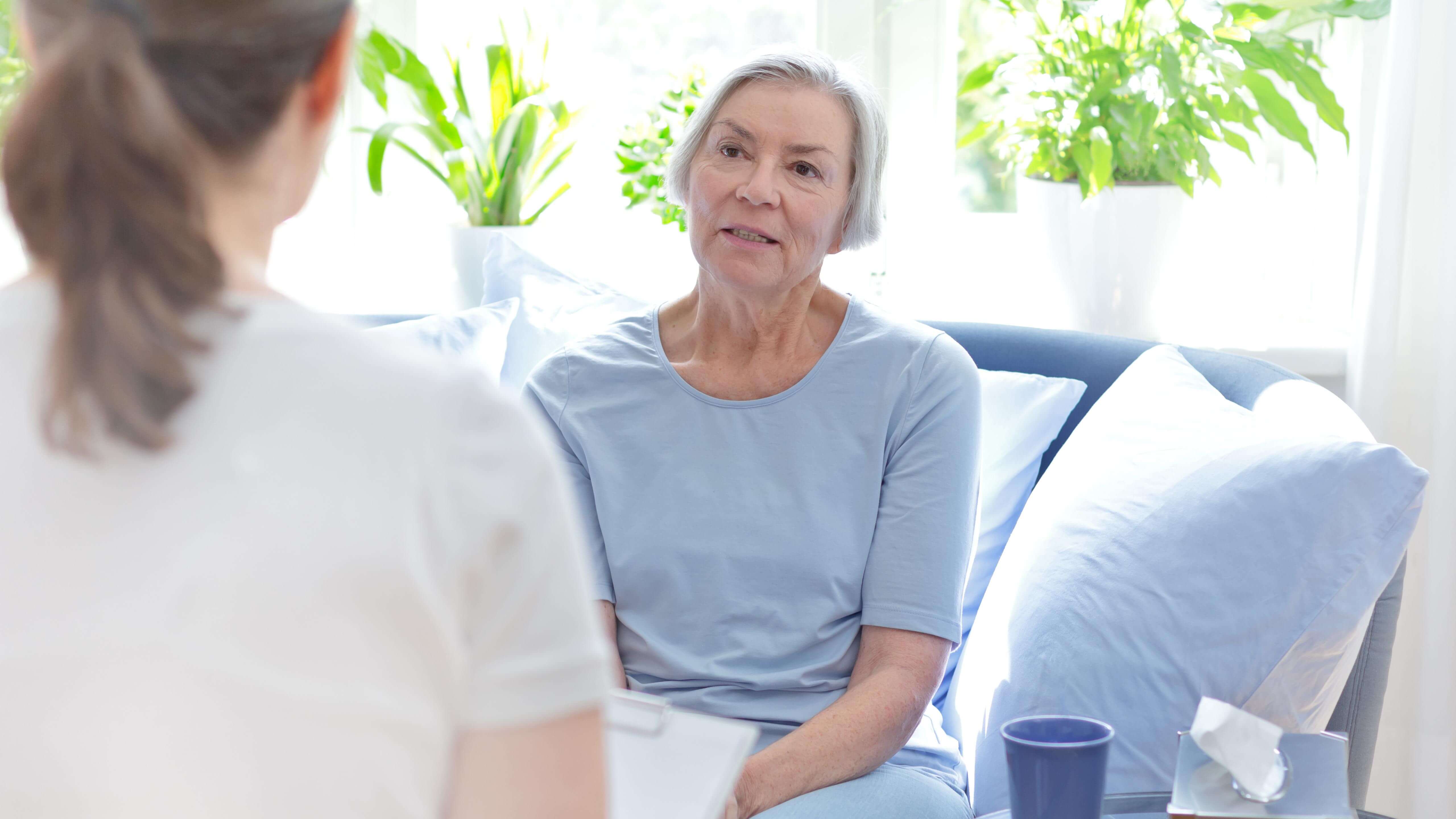 Elderly woman talking to a psychologist on a couch
