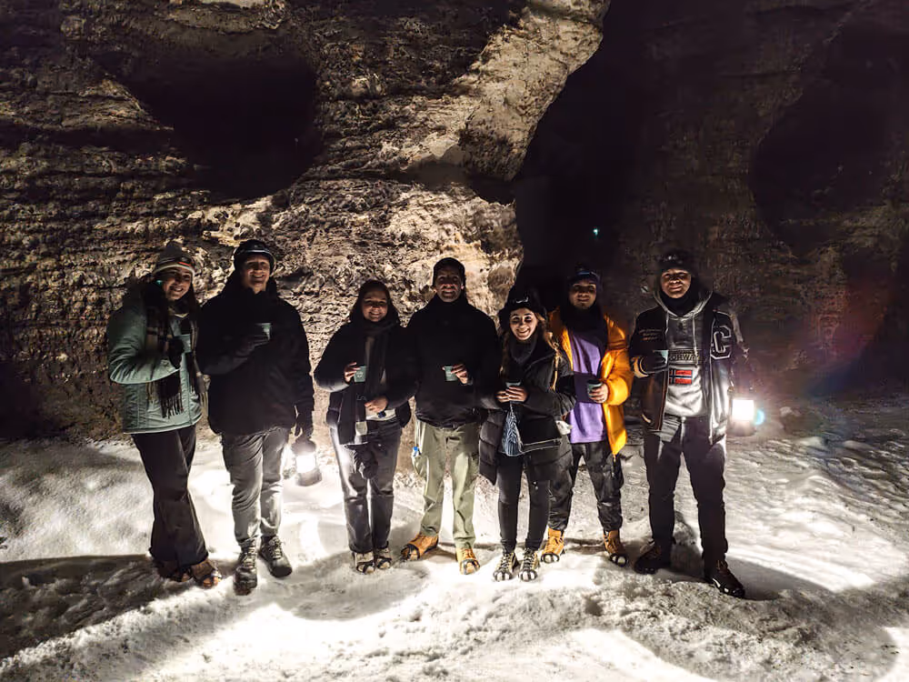 Guests warm up with hot drinks at the Tisa Rocks, lanterns lighting the snow – Narnia Lanterns Winter Tour.