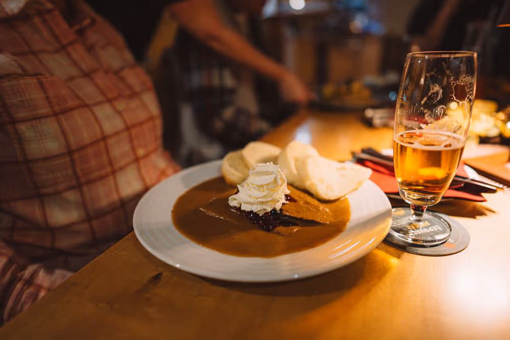 Traditional Czech dumplings with sauce and beer – post-hike dinner included on the Narnia Lanterns Winter Tour.