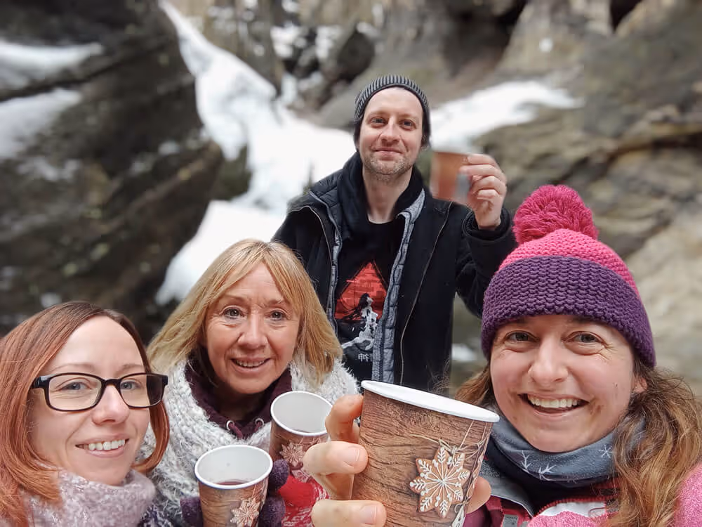 Happy group selfie enjoying hot mulled wine during the Narnia & Bastei winter tour at the Tisa Rocks.