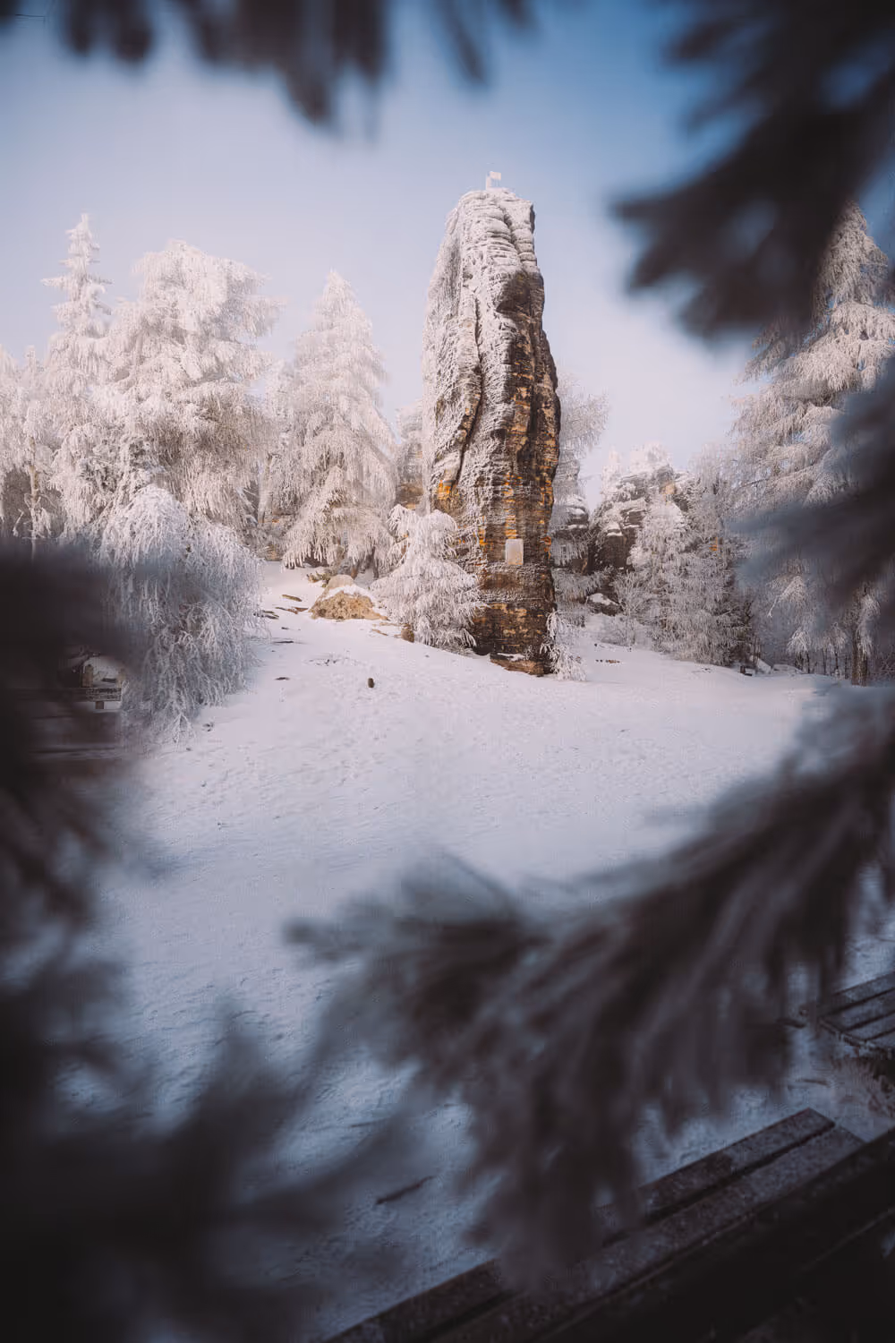 Snowy sandstone rock tower at the Tisa Rocks framed by frosted trees in Bohemian Switzerland, seen on the Narnia & Bastei tour.