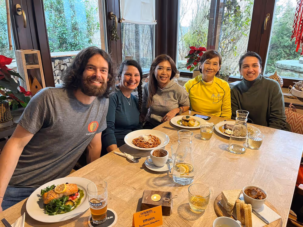 Happy travelers enjoying a traditional Czech lunch together at a countryside restaurant near Bohemian Switzerland National Park.