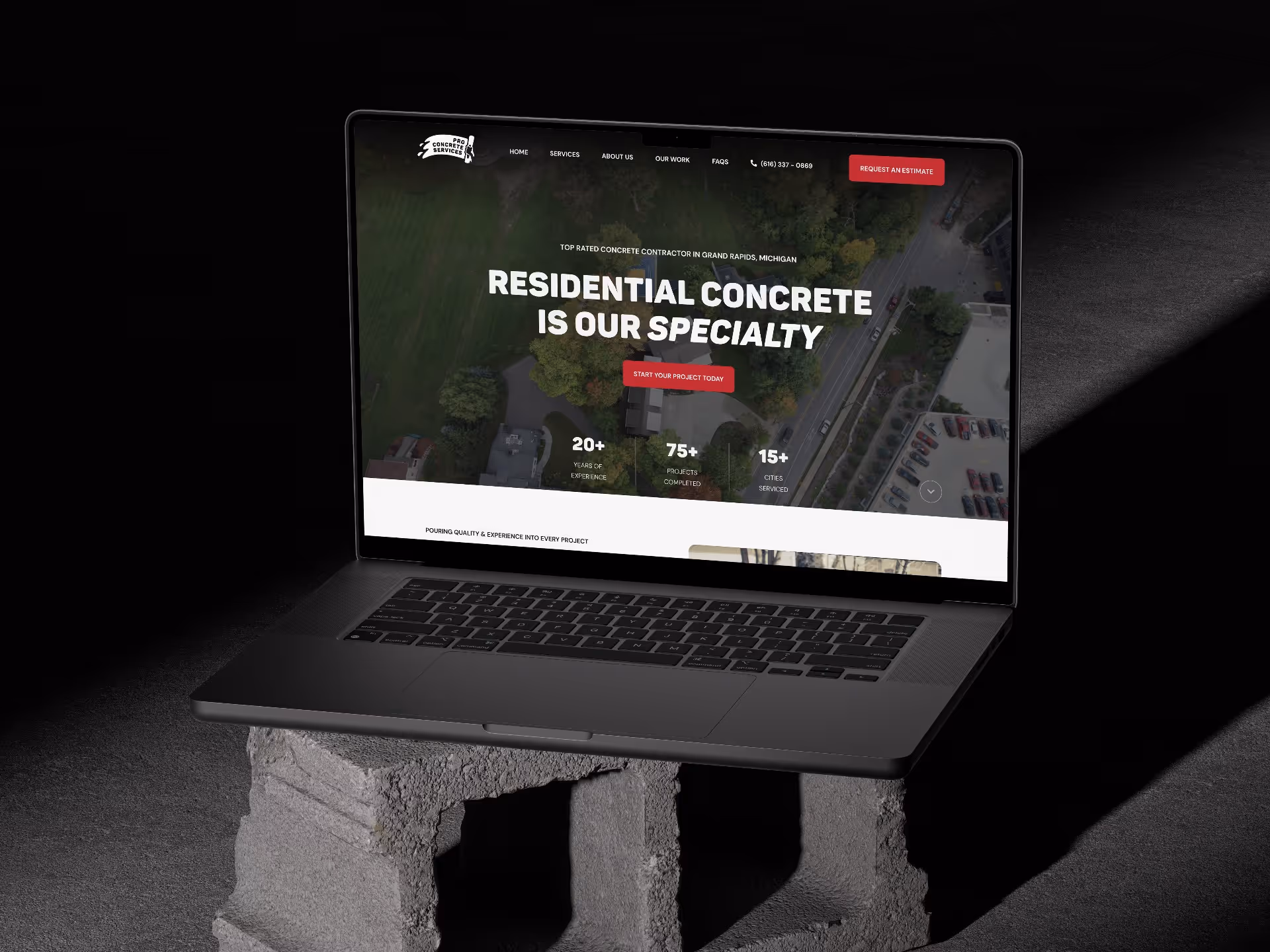 Pro Concrete Services homepage featured on Macbook Pro computer sitting on cinderblock