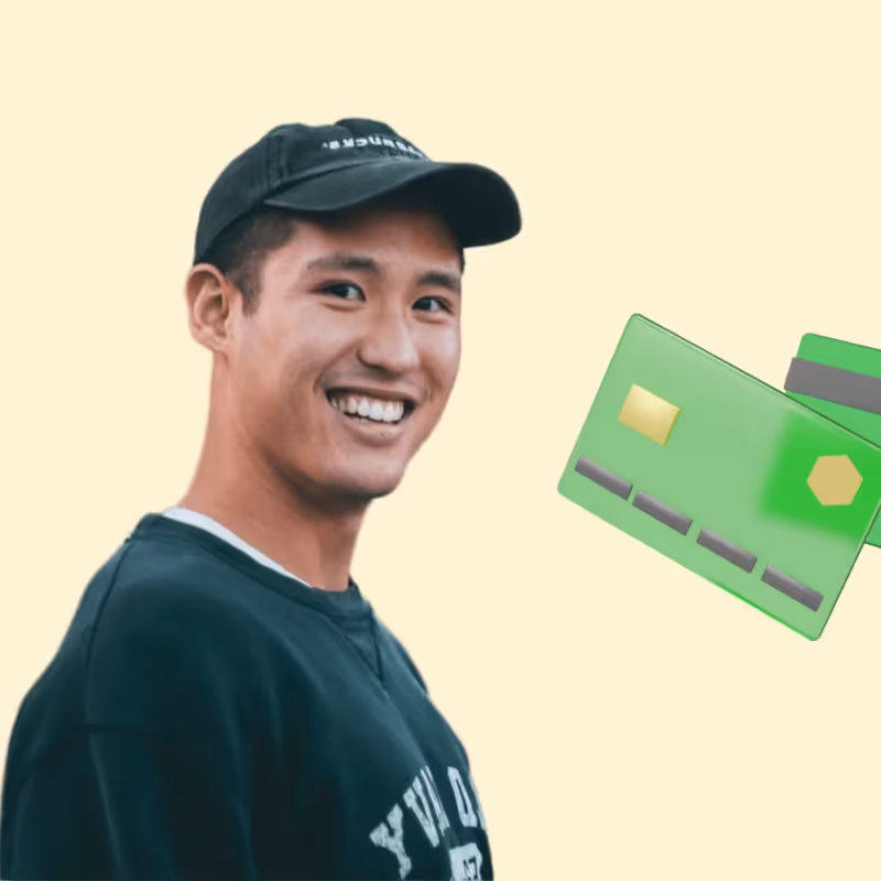 Smiling man with hat on and credit cards floating around him.