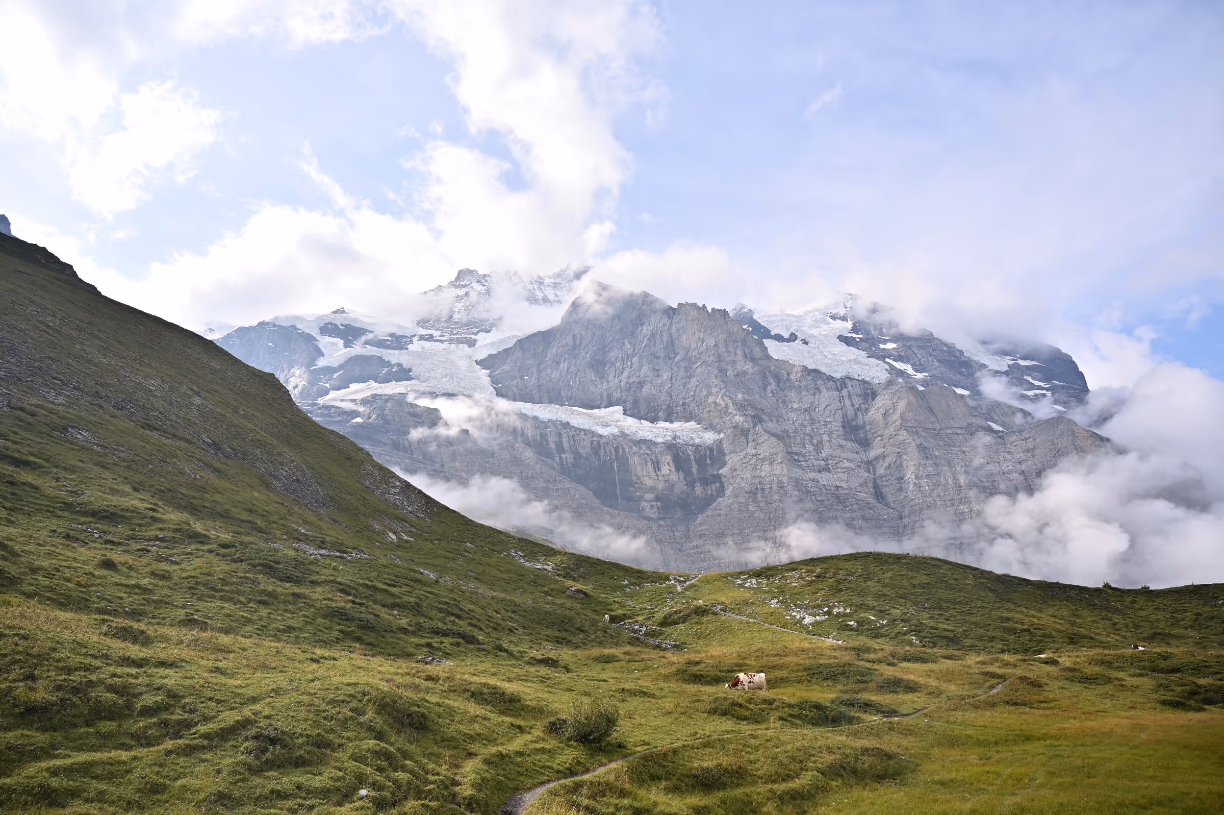 Alpine slopes and rocky peaks near Kleine Scheidegg as clouds begin to clear.