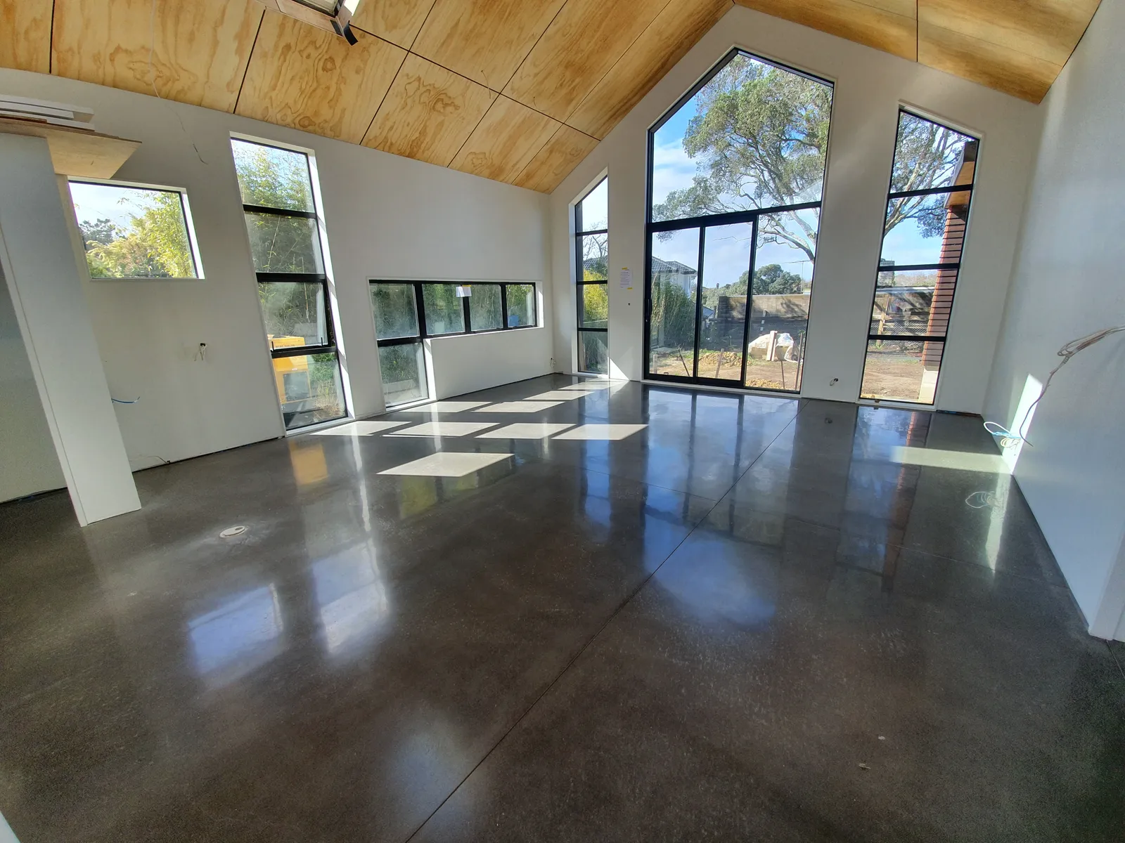 Diamond Shine Concrete high-gloss polished concrete floor in a modern open-plan Auckland new build with A-frame ceiling
