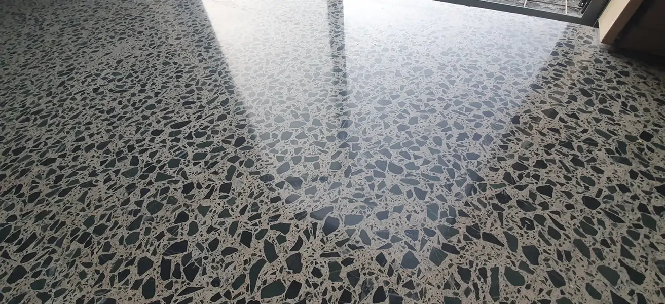 Diamond Shine Concrete matte polished concrete floor with exposed aggregate in a rustic Auckland home with timber beams and stone walls