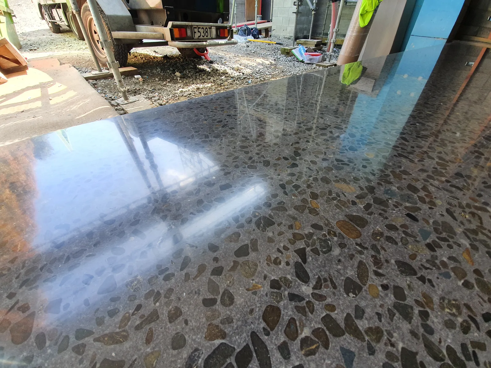 Diamond Shine Concrete high-gloss polished garage floor with exposed aggregate finish in Auckland, reflecting surroundings like a mirror