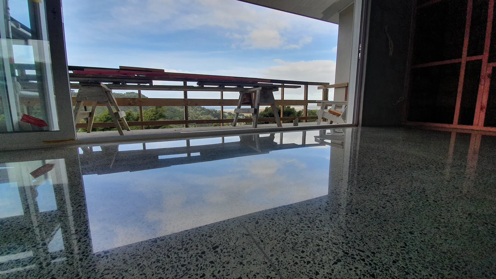 Diamond Shine Concrete high-gloss polished concrete floor during construction phase in Auckland, reflecting clouds with mirror finish