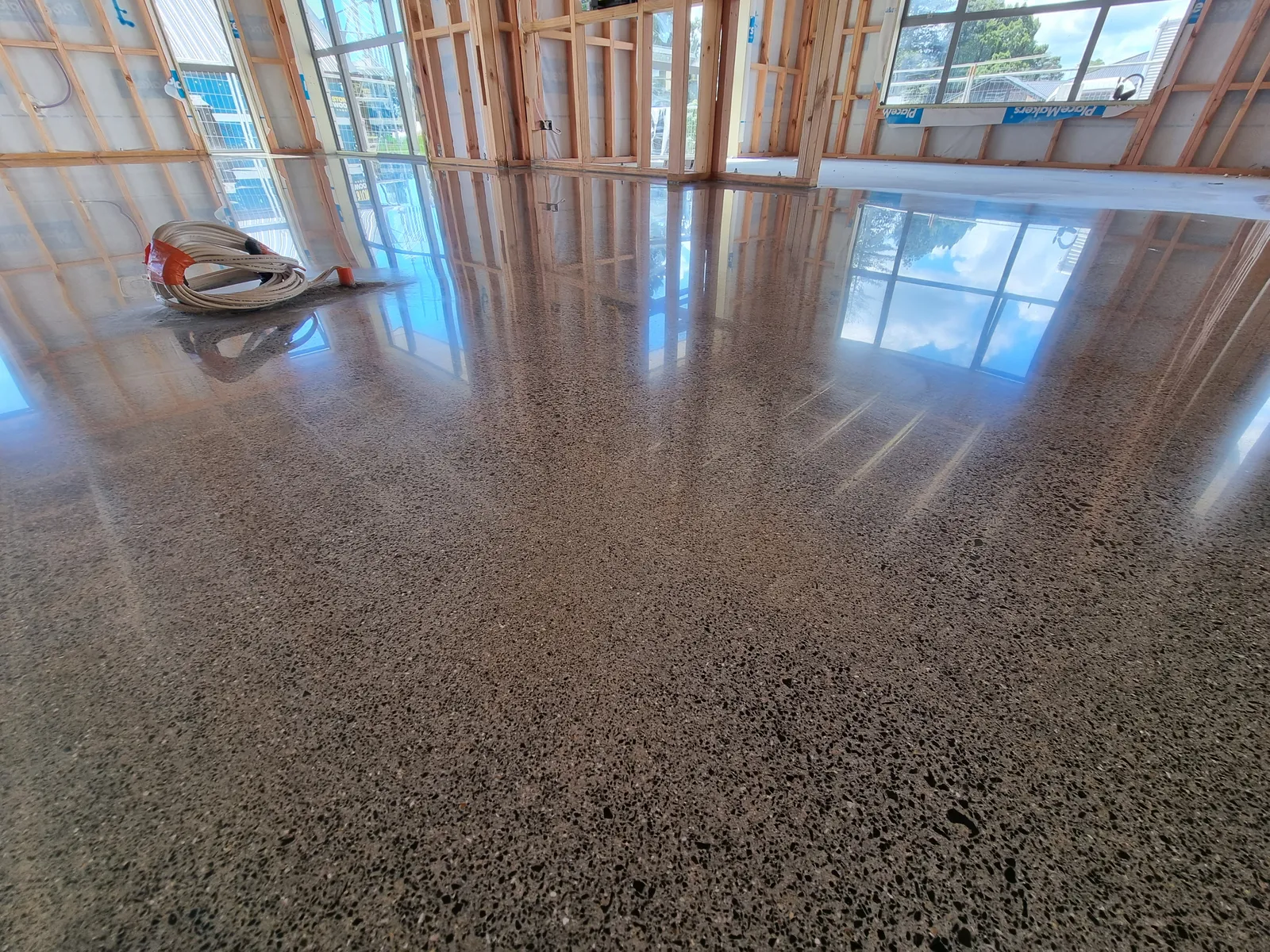 Diamond Shine Concrete light grind high-gloss polished concrete floor in an Auckland new build under construction