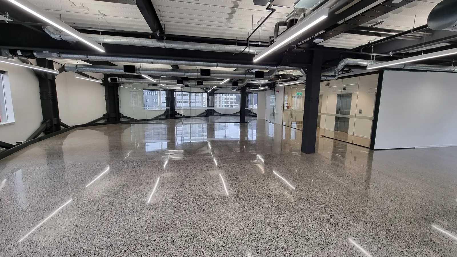Diamond Shine Concrete mirror-finish polished concrete floor in large Auckland commercial space with exposed aggregate and natural light