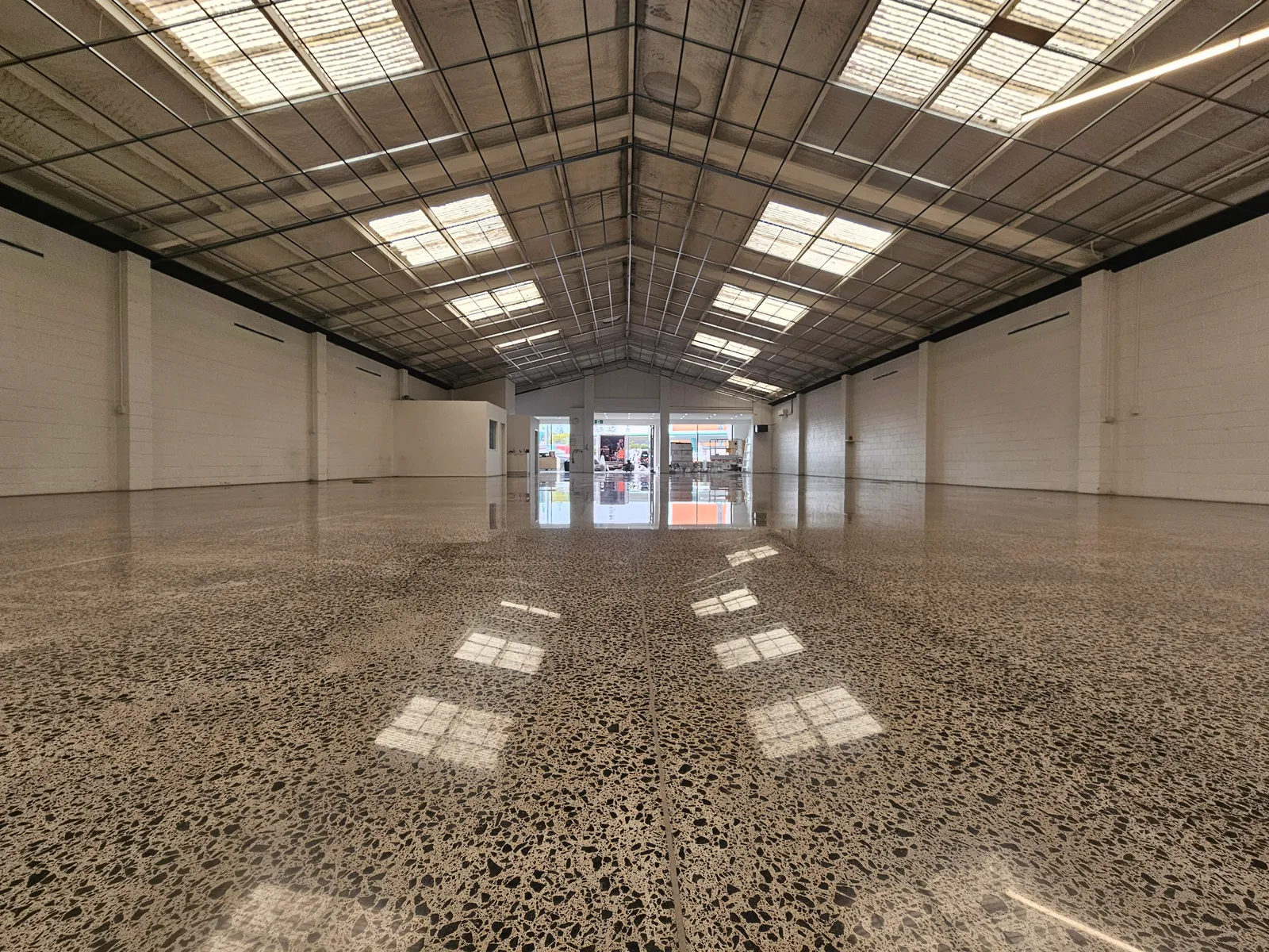 Diamond Shine Concrete mirror-finish polished concrete floor in large Auckland commercial space with exposed aggregate and natural light