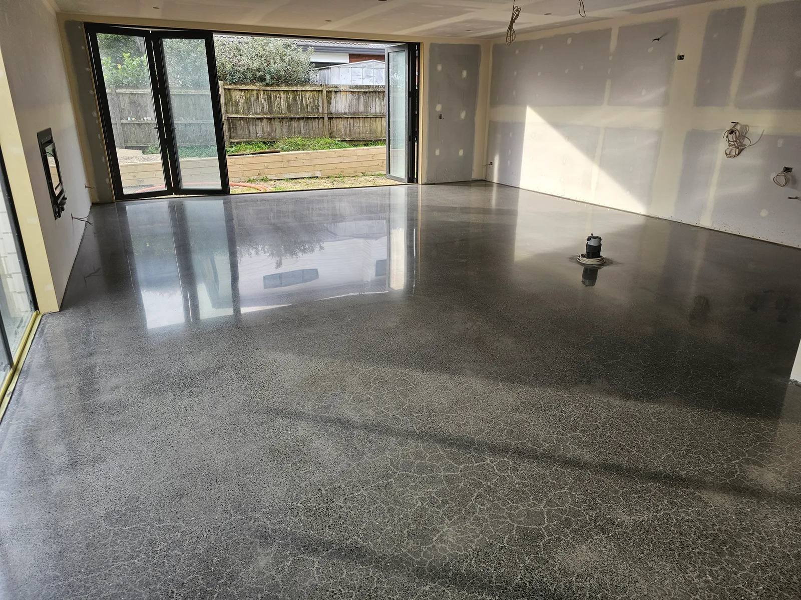 Diamond Shine Concrete polishing concrete floor in progress in Auckland new build open-plan living area with high-gloss finish