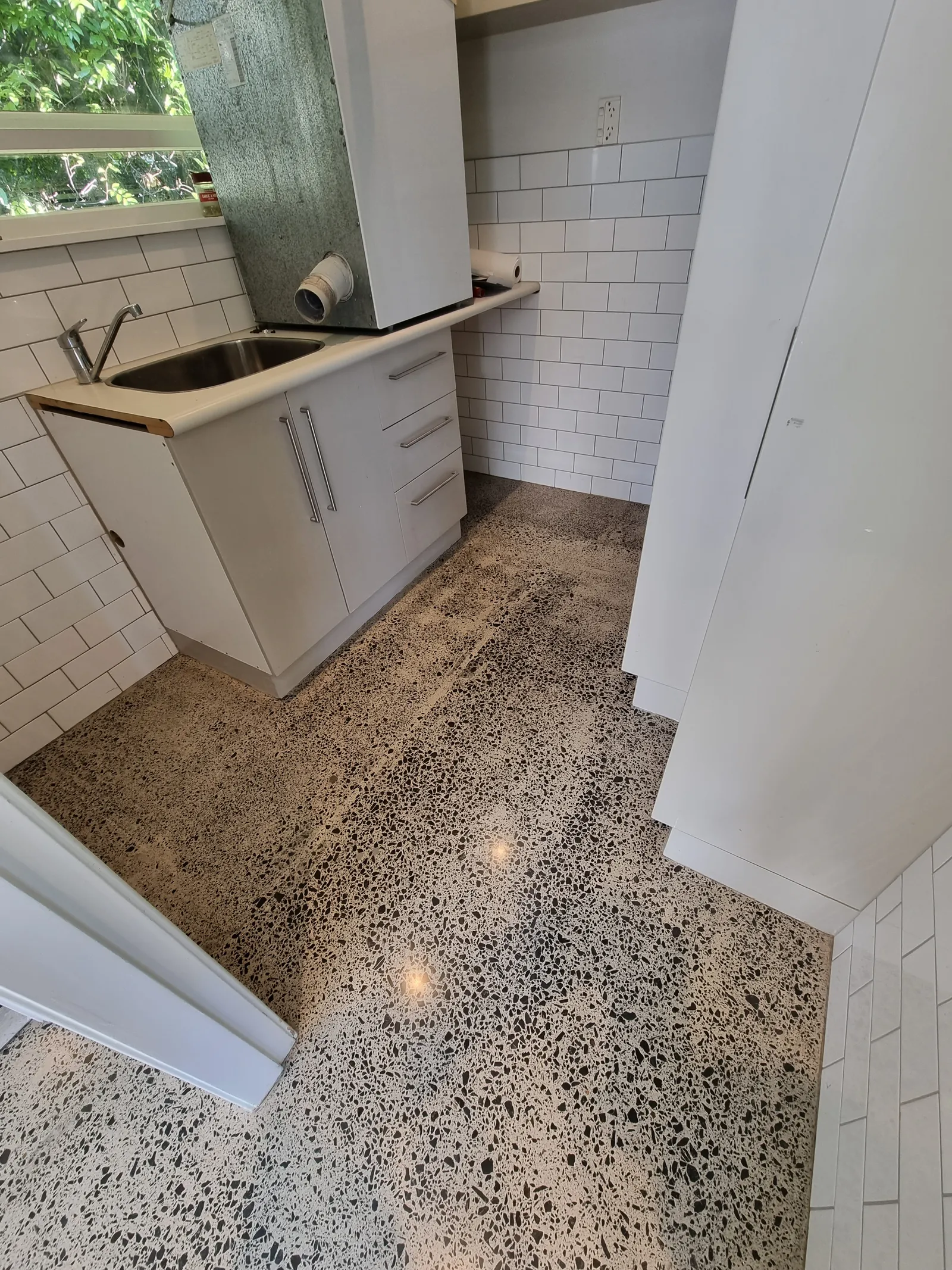 Diamond Shine Concrete high-gloss polished pre-1990 concrete floor in an Auckland residential laundry with exposed aggregate