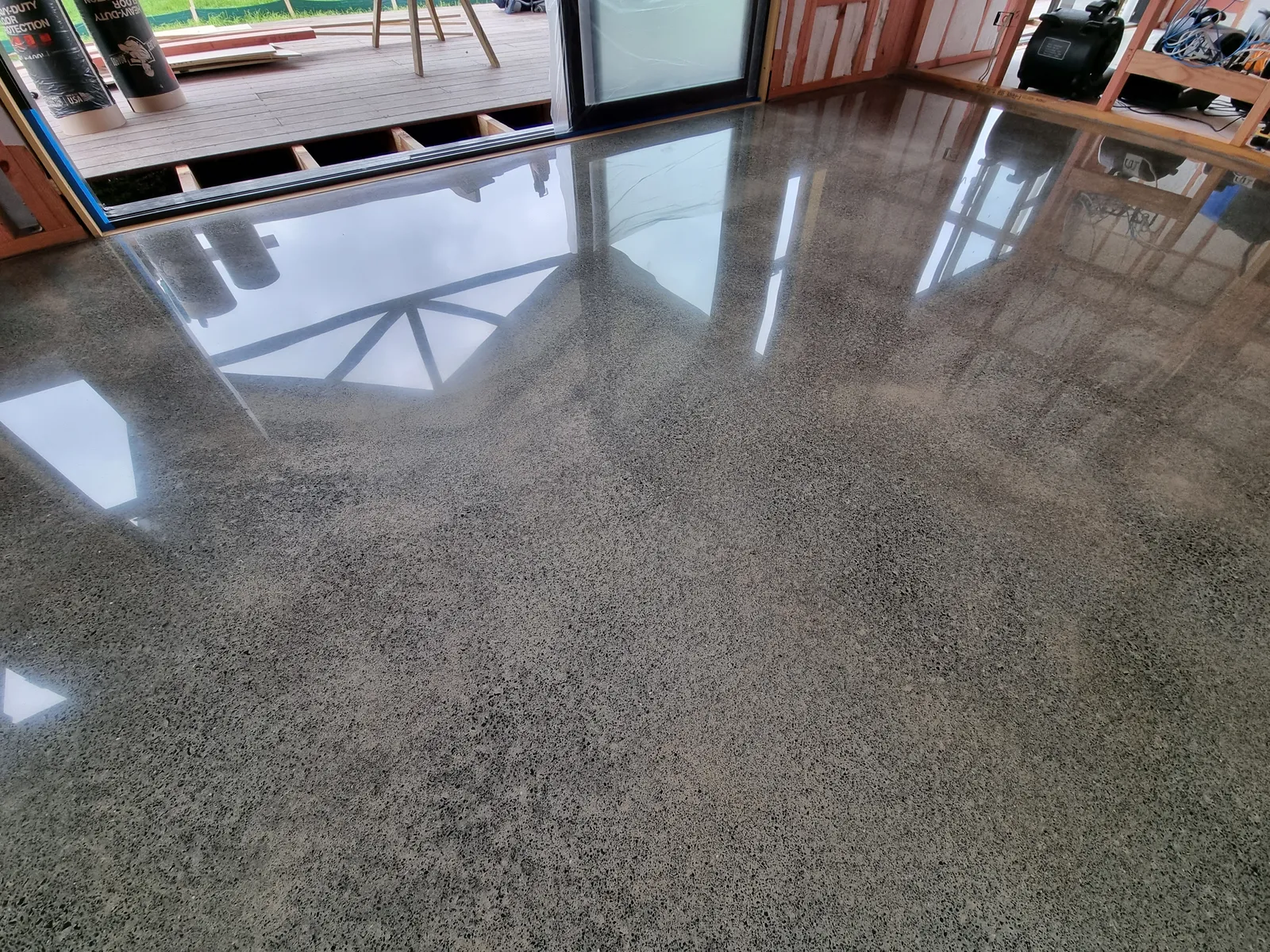 Diamond Shine Concrete light grind polished concrete floor near deck access in an Auckland residential new build