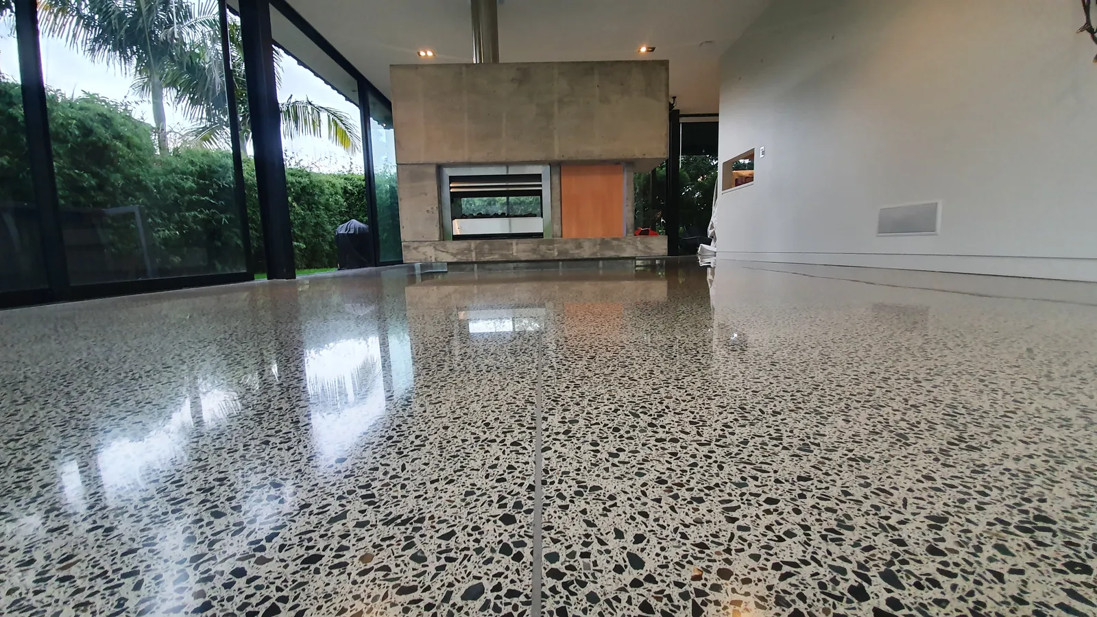 Diamond Shine Concrete high-gloss polished concrete floor with fireplace feature in Auckland home renovation