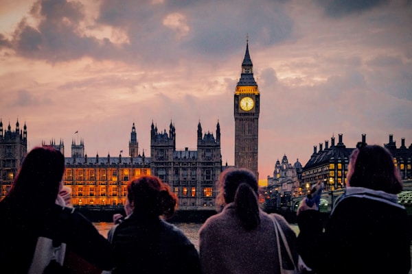 A group of people standing in front of a clock tower