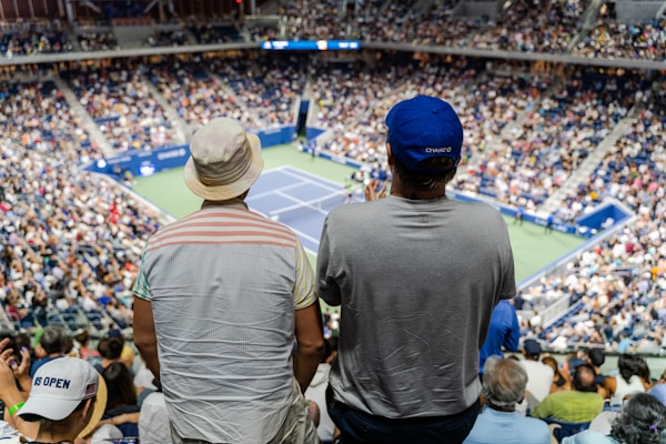 Two fans stand to cheer on tennis action during the 2022 US Open in New York City