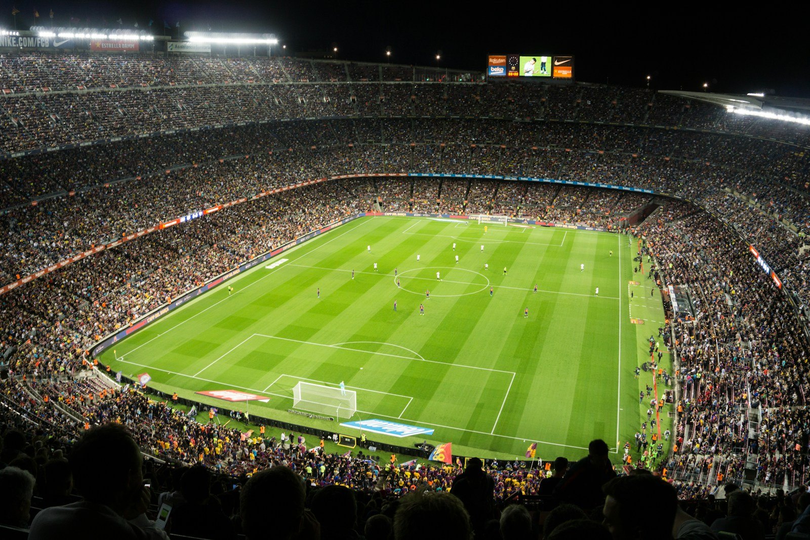 Un grand stade de football plein, un soir de match, vu depuis les tribunes hautes