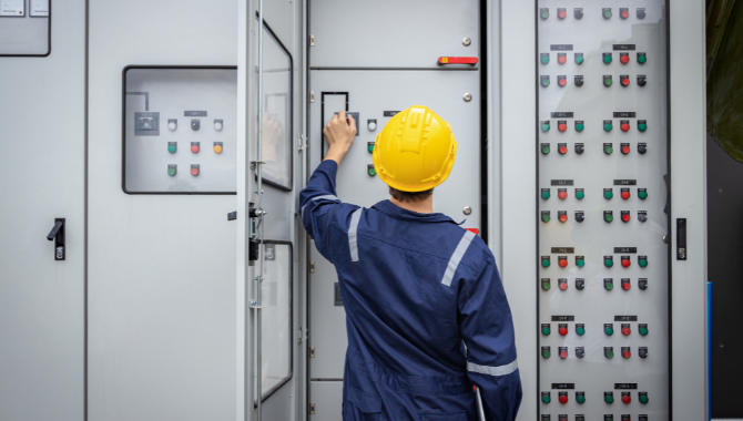 Engineers in safety gear participating in hands-on team training at an industrial facility, using power tools for technical work.