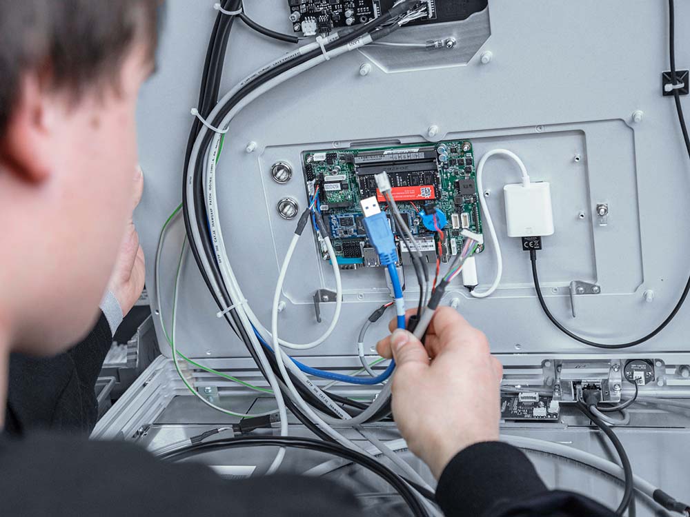 Close up of hands wiring a board inside a panel