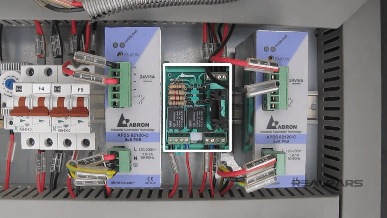 Electrical panel featuring power supplies, labeled fuses (F4, F5), and a control circuit board for system protection.